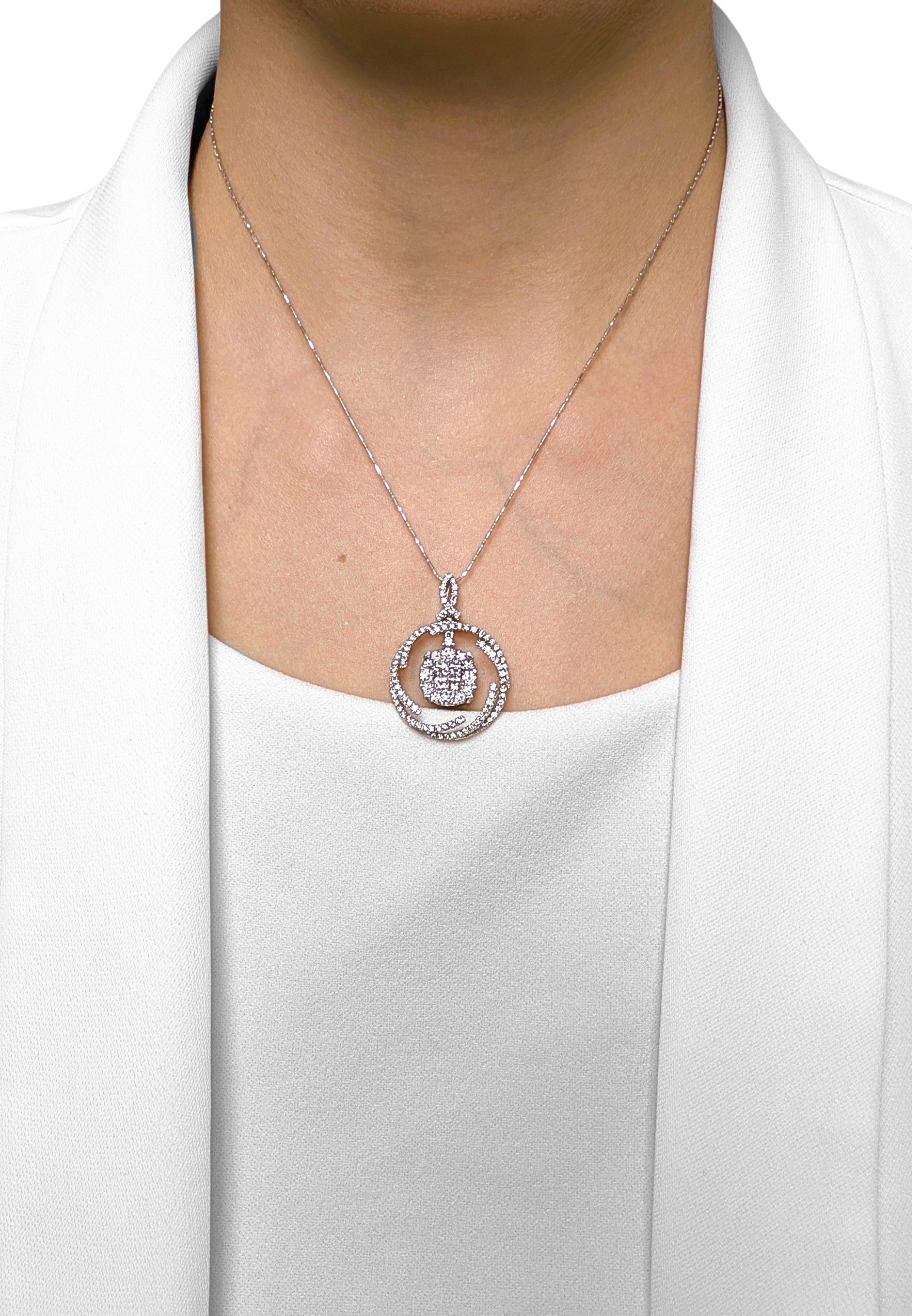 Dieser Anhänger glänzt mit 4 Diamanten im Prinzessinnenschliff (0,20 ct) in seinem Kern, umgeben von einem Halo aus 117 runden Brillanten (0,82 ct), alle mit der Farbe G-H und der Reinheit VS bewertet. Das mehrschichtige Design verbindet