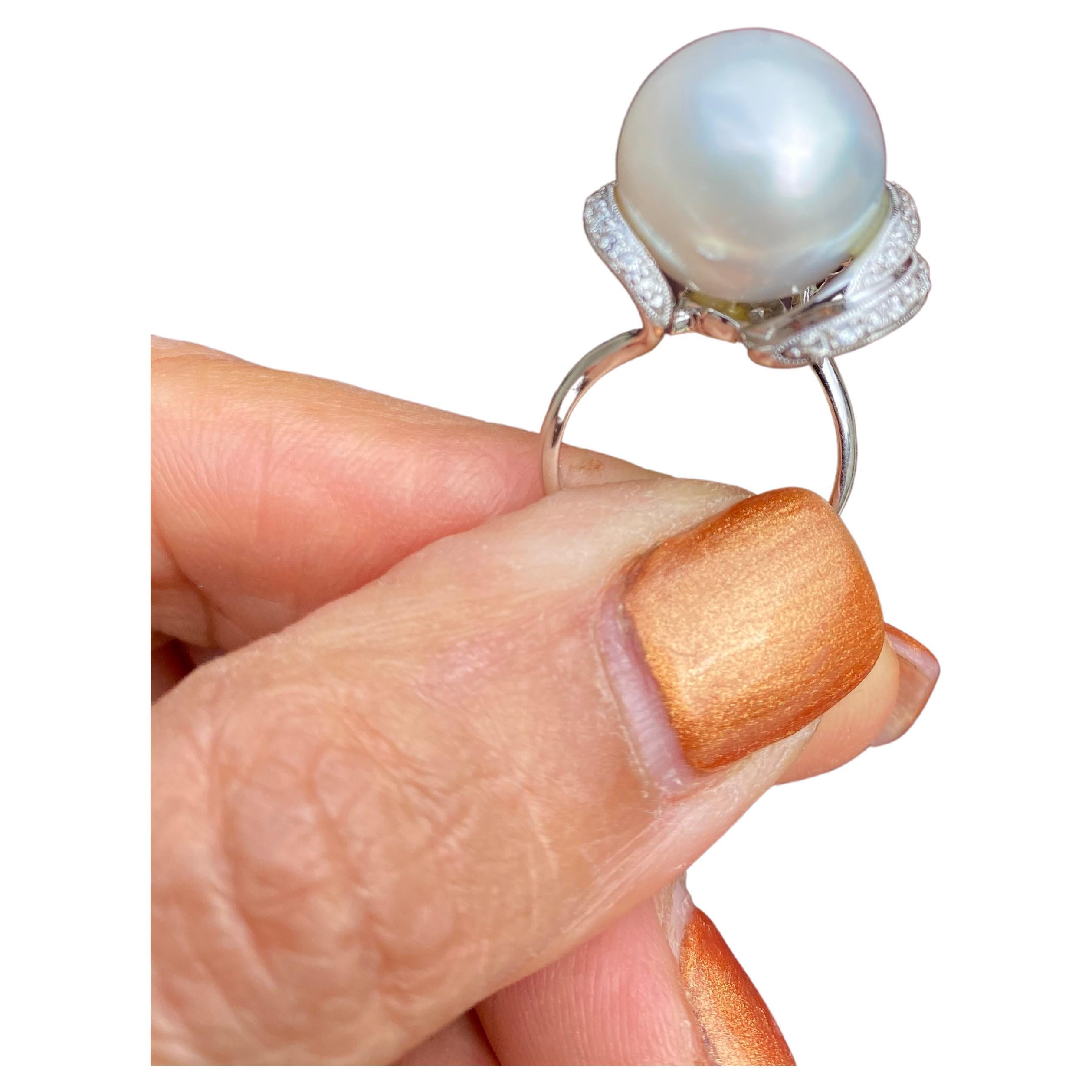 Showcasing a 15.50 mm White South Sea Pearl set with Diamonds in this 18 karats white gold Ring 
A luxurious, white glowing pearl of AAA quality is set in a Contemporary setting with three bars of diamonds. Each bar is charged with pave diamonds