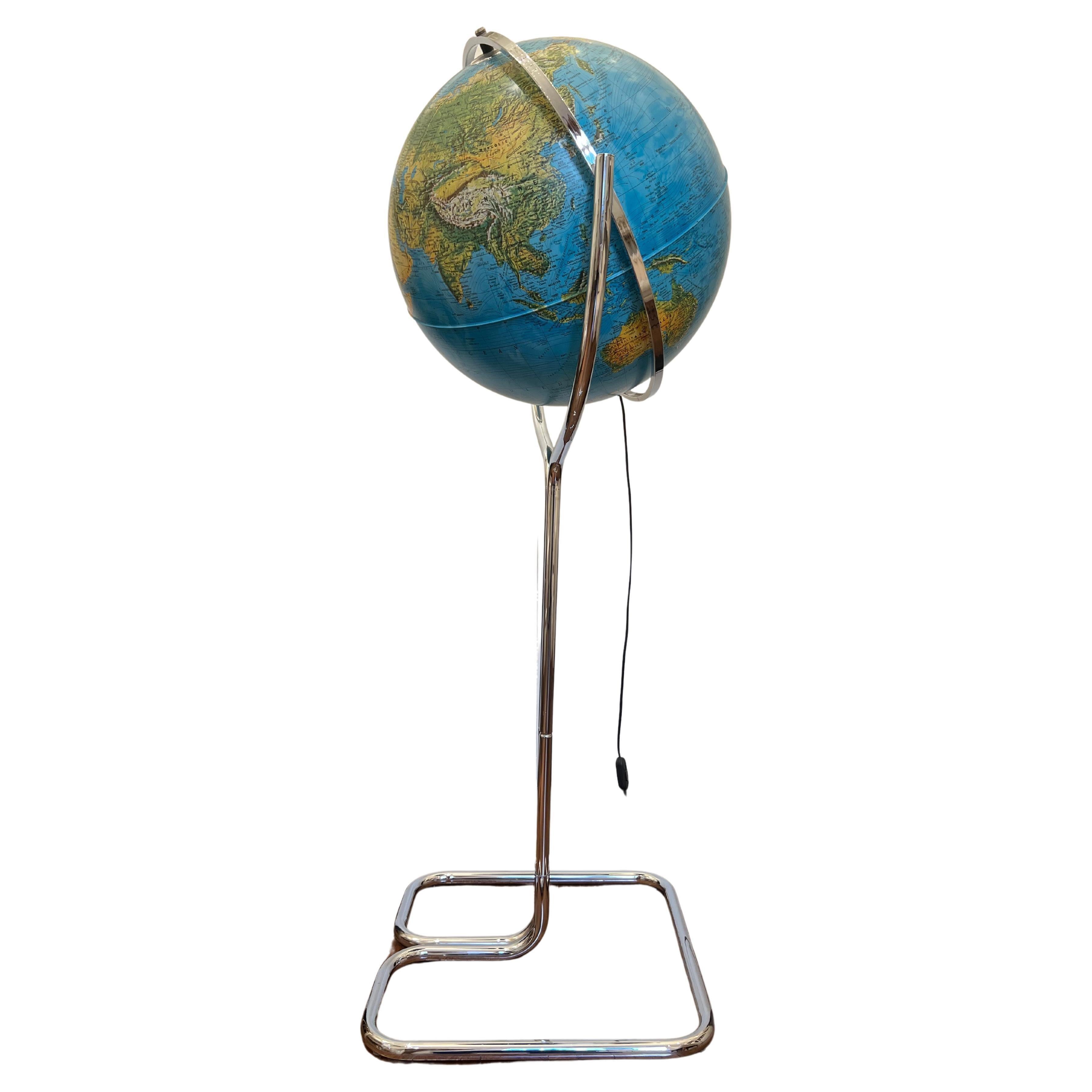 Globe lumineux insolite sur une grande base en métal chromé, fabriqué en Italie par les éditions Ricoscope à Firenze.
En parfait état, à l'exception de deux très petites pièces manquantes à la jonction des deux demi-lunettes (voir dernière