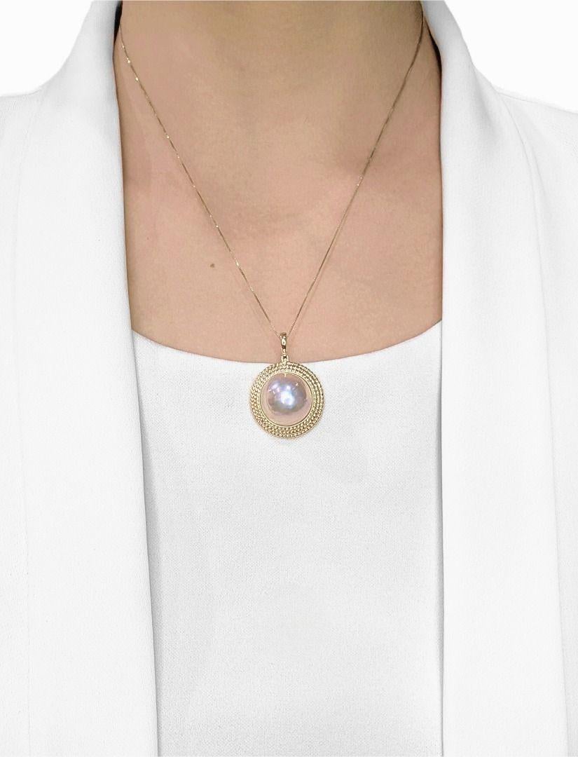 Zeitlose Eleganz trifft auf Vintage-Charme in diesem atemberaubenden Perlenanhänger von Mabe. Das aus 14-karätigem Gelbgold gefertigte Schmuckstück ist mit einer leuchtenden 17 mm großen, runden Mabe-Perle in einem zarten rosa-weißen Farbton