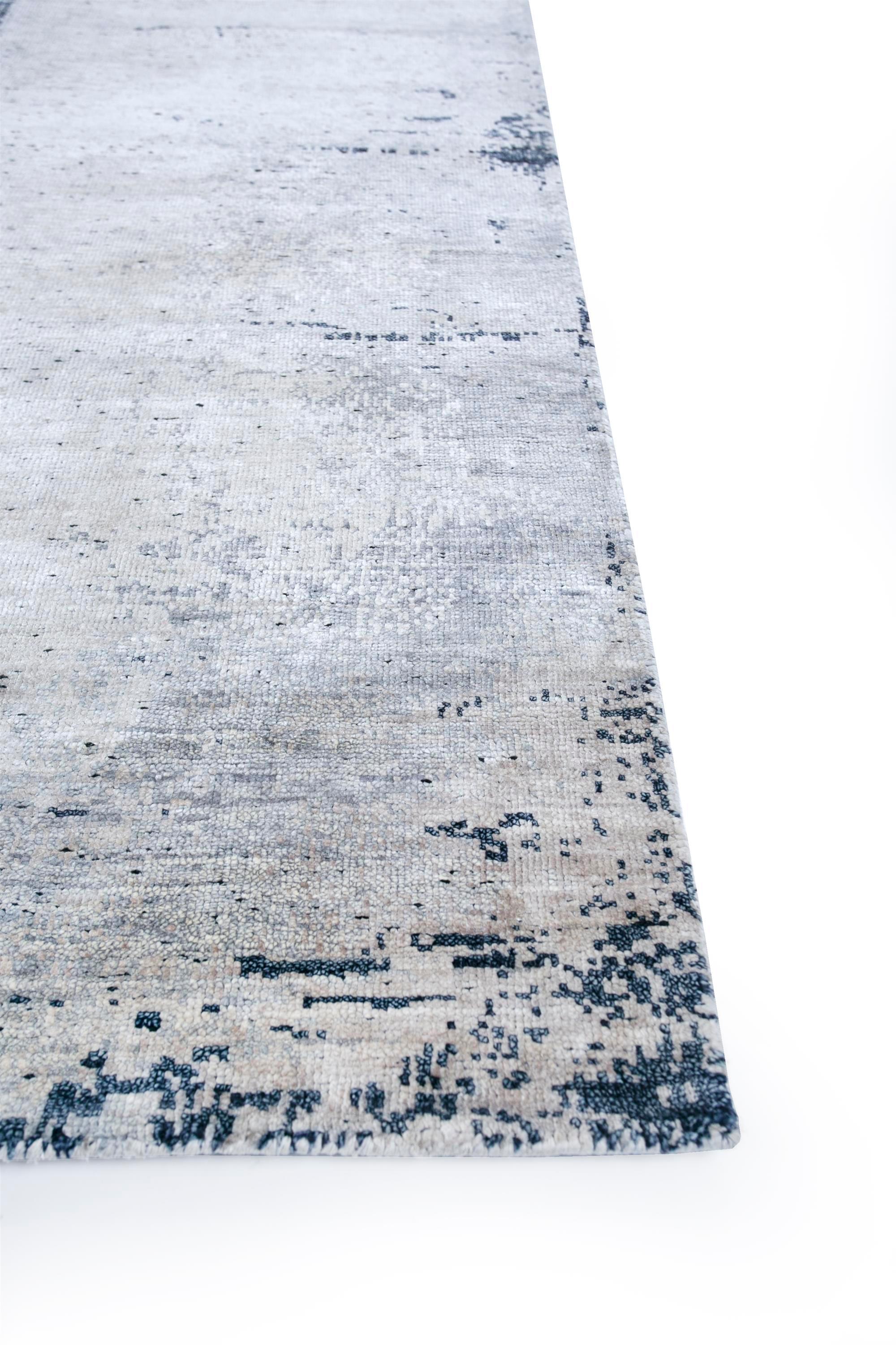 Avez-vous découvert le pouvoir de transformation des palettes ton sur ton ? Découvrez ce tapis moderne noué à la main, fabriqué de manière exquise dans l'Inde rurale. Avec une base blanche sereine et une bordure blanc lin, ce tapis rehausse
