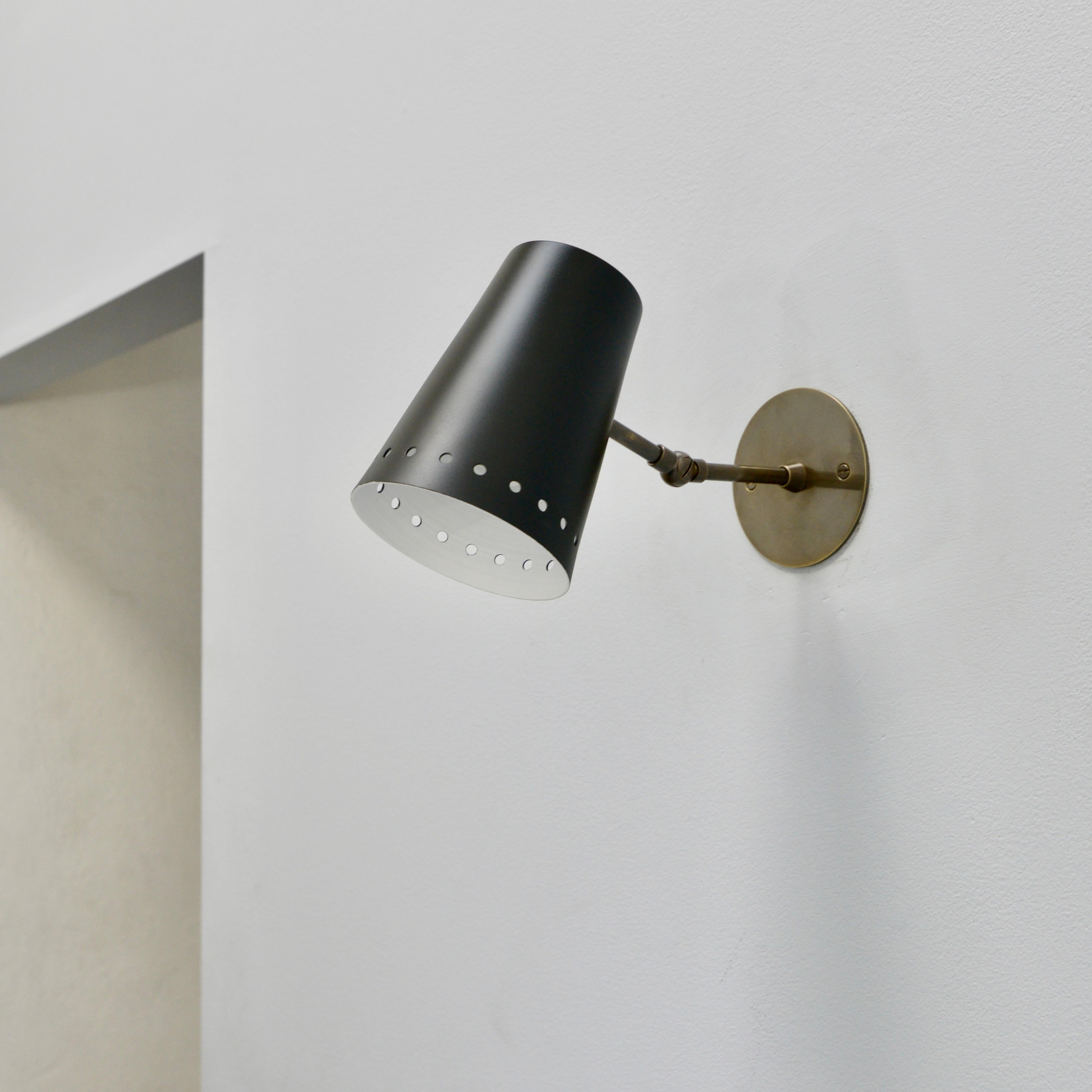 Directional LUmmer sconce by Lumfardo Luminaires. Based in a German design the sconce is made In patina brass and a painted aluminum shade. E12 candelabra based socket. Priced individually. Lightbulbs and mounting hardware supplied with