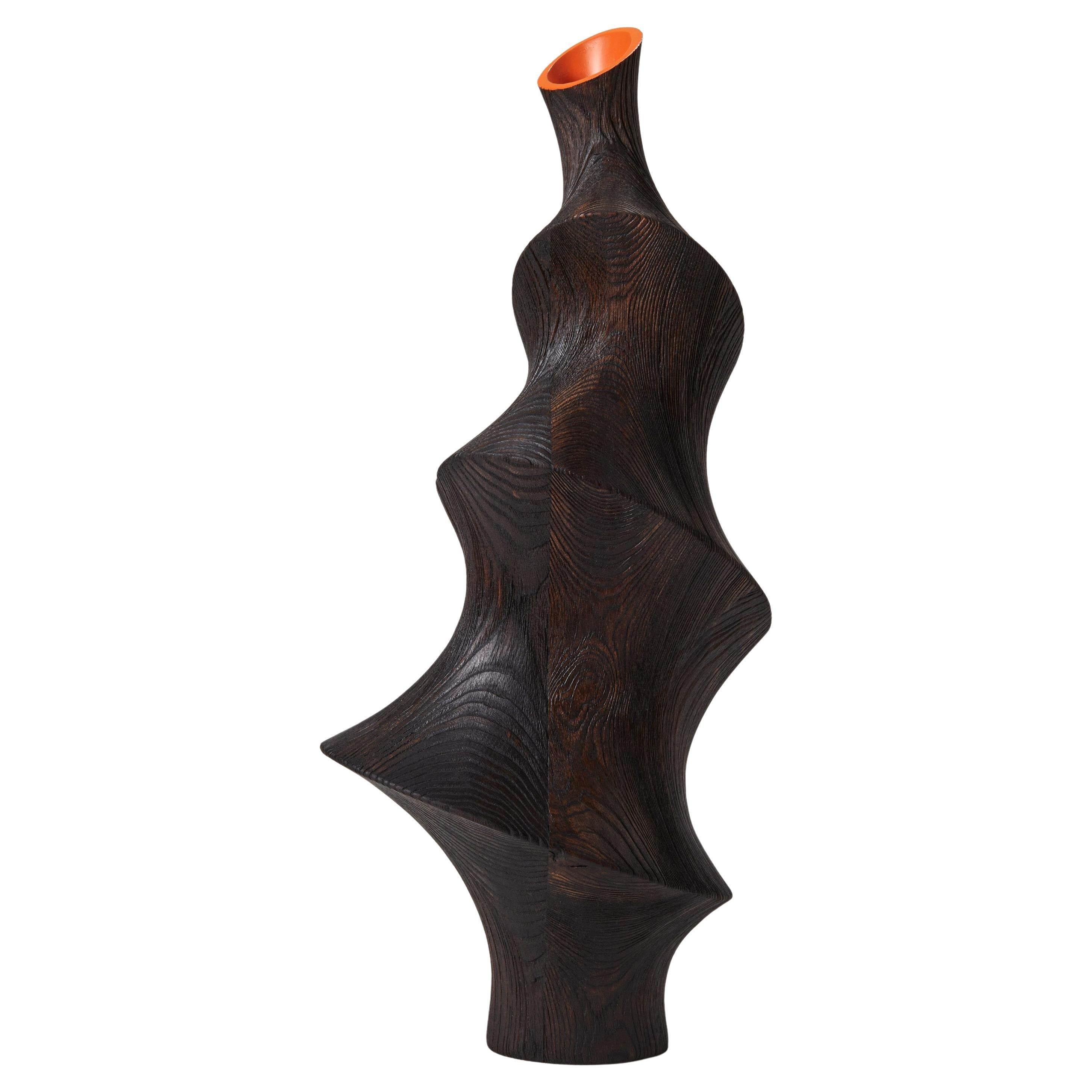 Lun 0.2, una scultura in legno scuro con nervature di frassino e interno arancione di Donald Baugh
