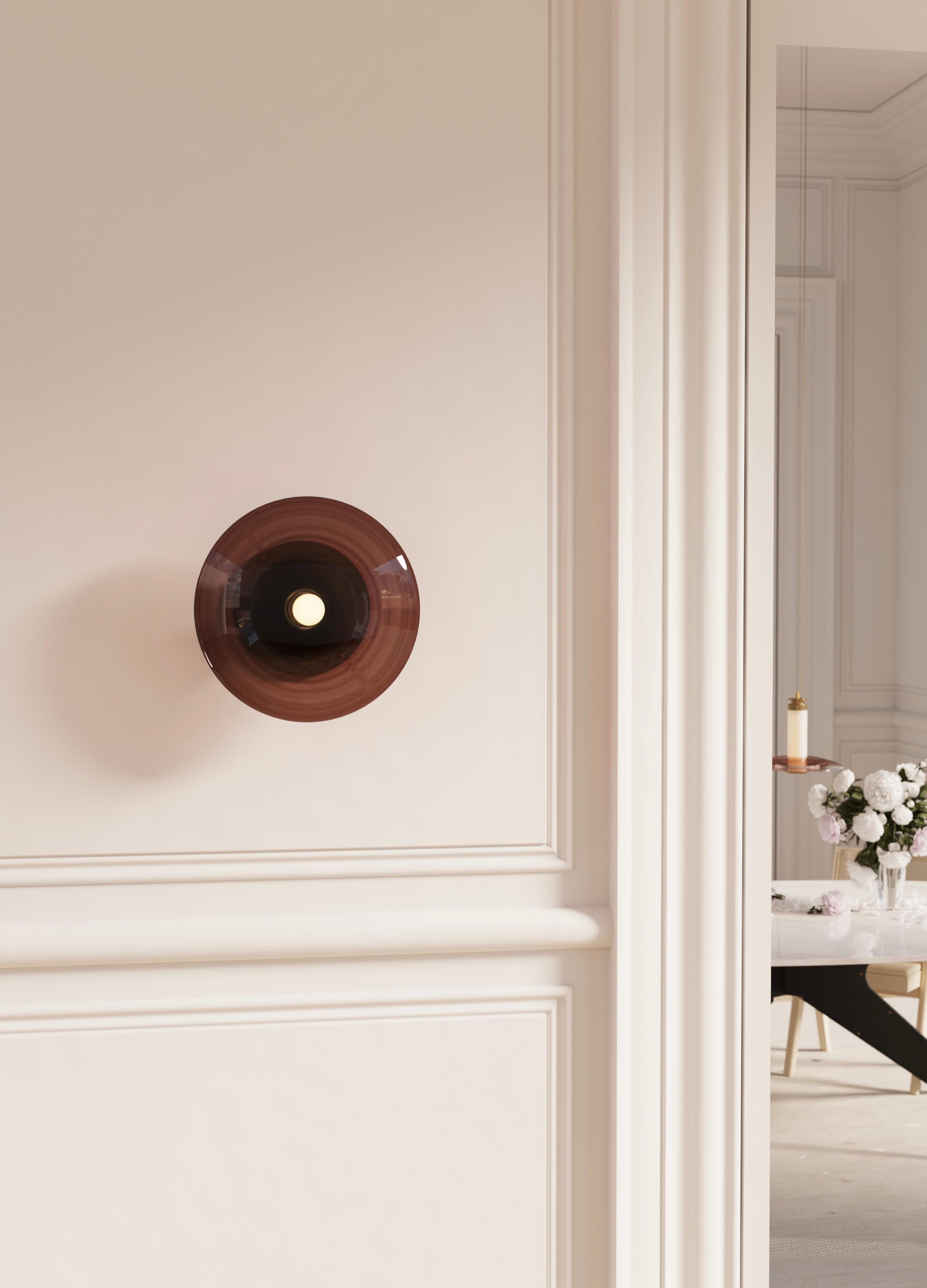 Highlighting the beauty of blown glass, the Luna A Round Sconce stands out by its simplicity and elegance. 

The Luna A Round Sconce in Satin Brass comes with Smoked Bronze Glass.