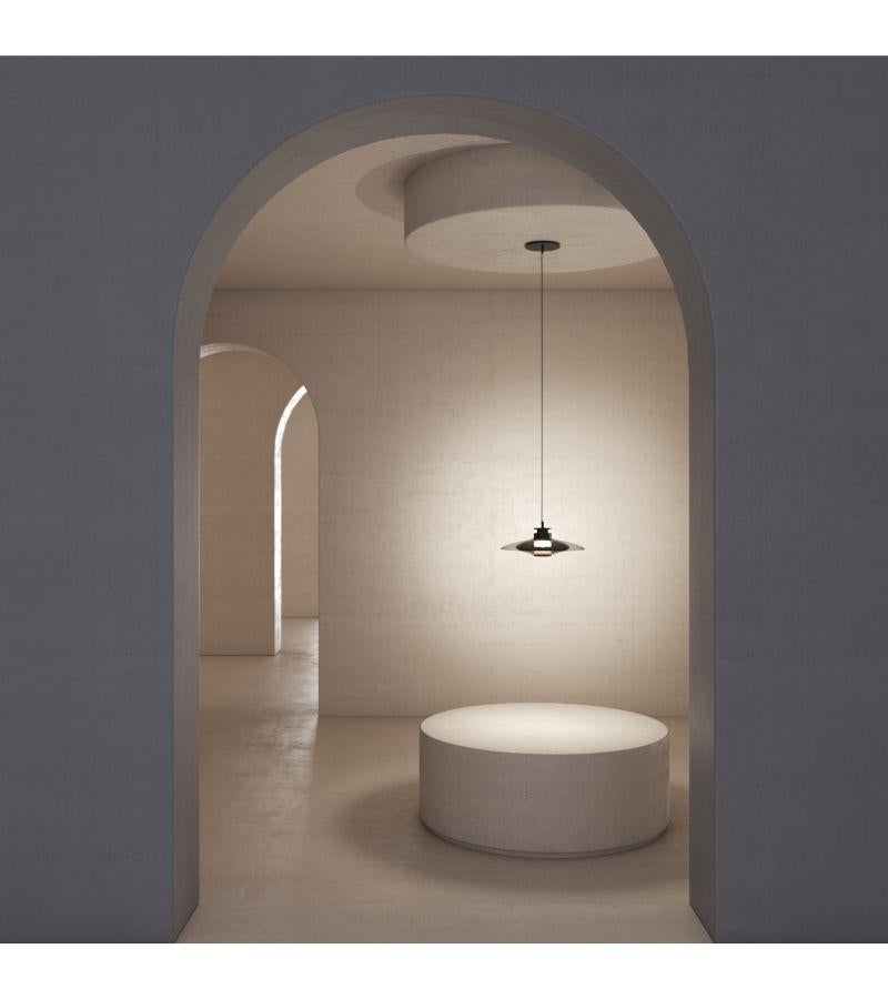 Highlighting the beauty of blown glass, the Luna A X-Small Disc Pendant stands out by its simplicity and elegance. Also available in black hardware with smoked glass and brass hardware with bronze glass, all Luna A Pendants are provided with an 8