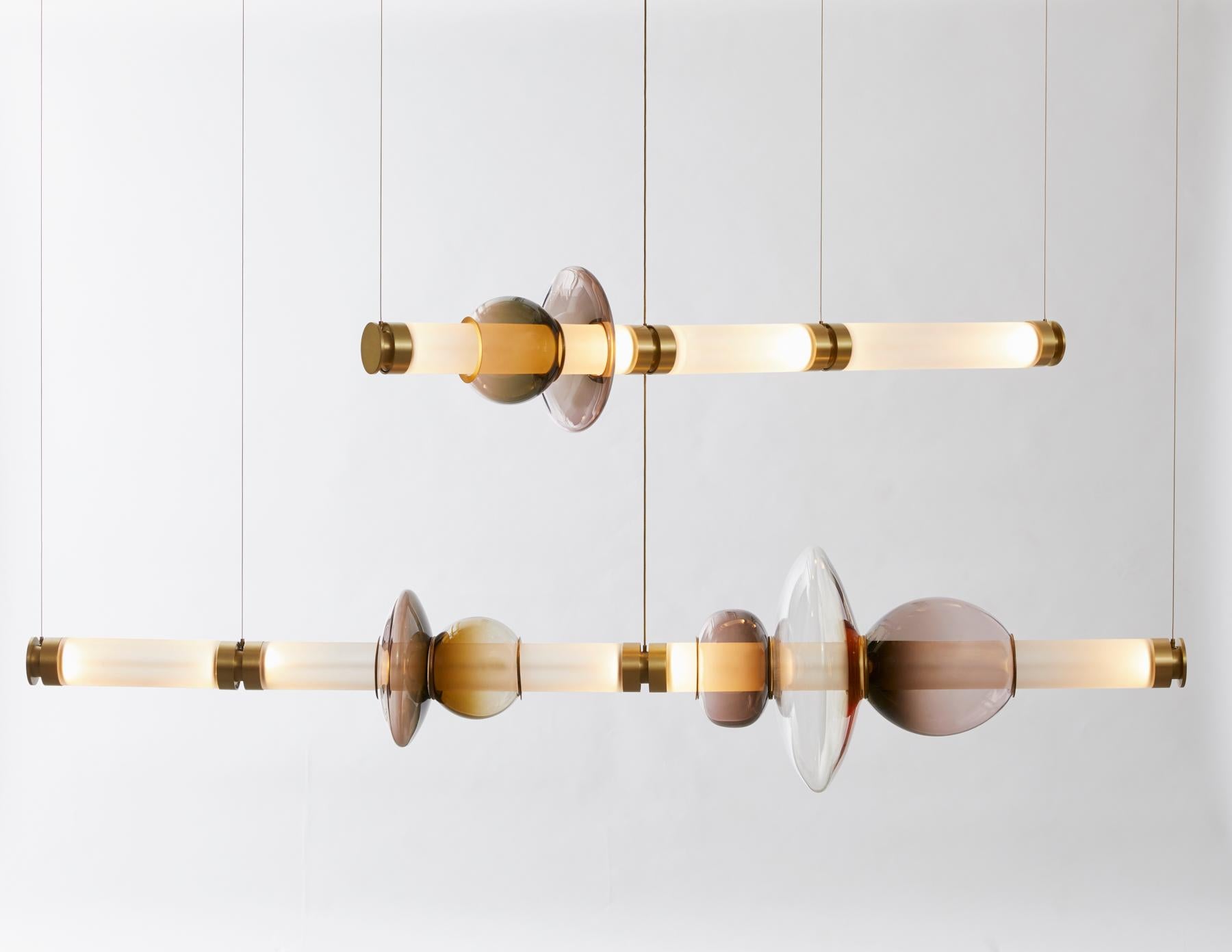A lighting system with infinite interpretations, the Luna Chandelier 2 Tier  is a synergy of color, shape, and refracted light. Inspired by a lunar halo, the modular light fixture grows in every direction as its assembly system stems horizontally or