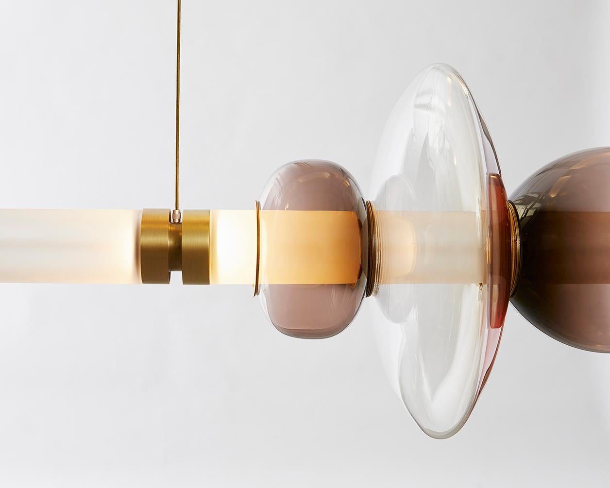 A lighting system with infinite interpretations, the Luna Chandelier XL 1 Tier  is a synergy of color, shape, and refracted light. Inspired by a lunar halo, the modular light fixture grows in every direction as its assembly system stems horizontally