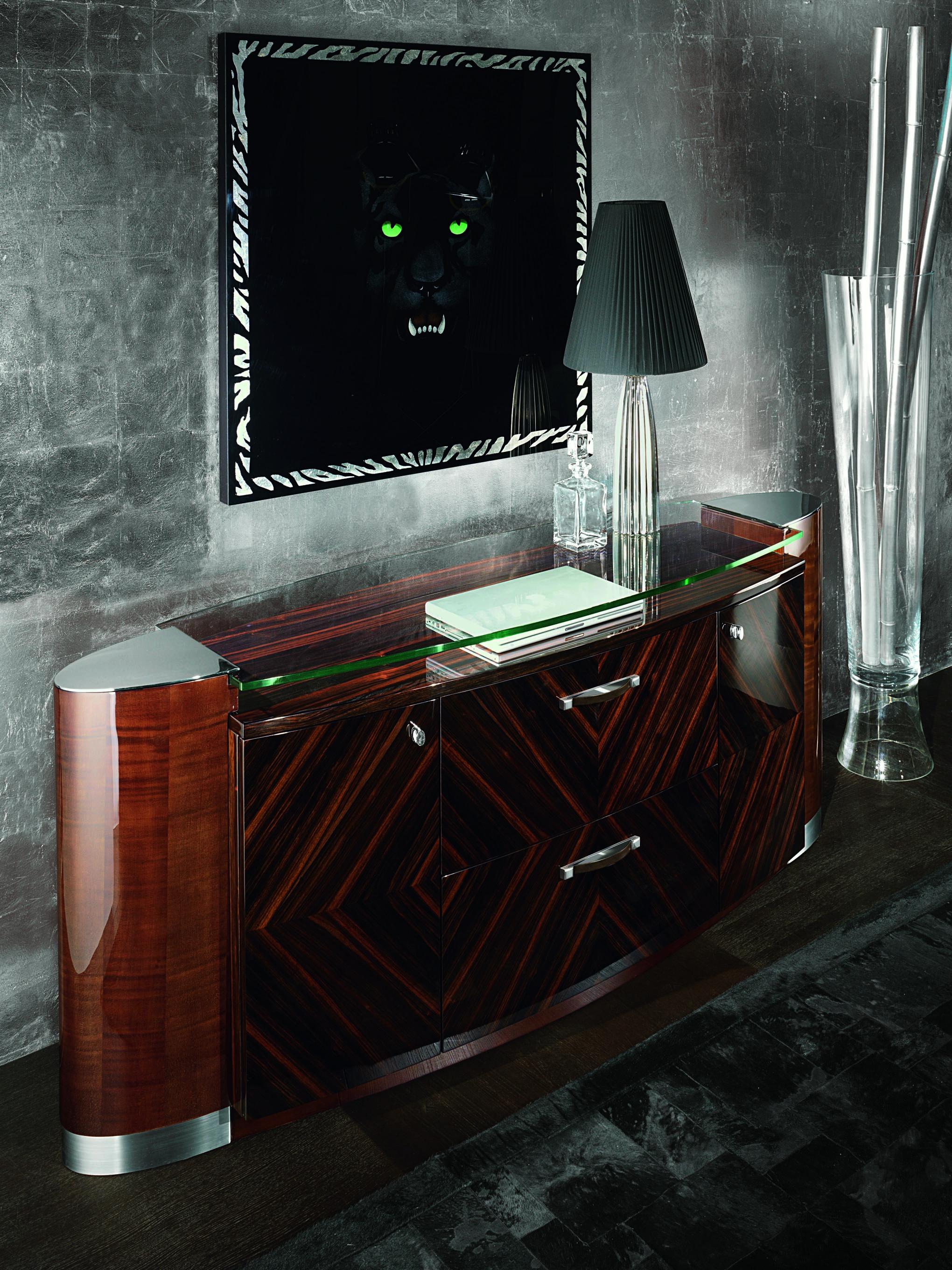Oval buffet in Ebony Makassar in high gloss polyester. 
2 center doors with 1 adjustable shelf and with 1 inside full extension drawer with bottom velvet inside. 
2 side doors with 2 adjustable shelves. 
Brushed and chrome stainless steel