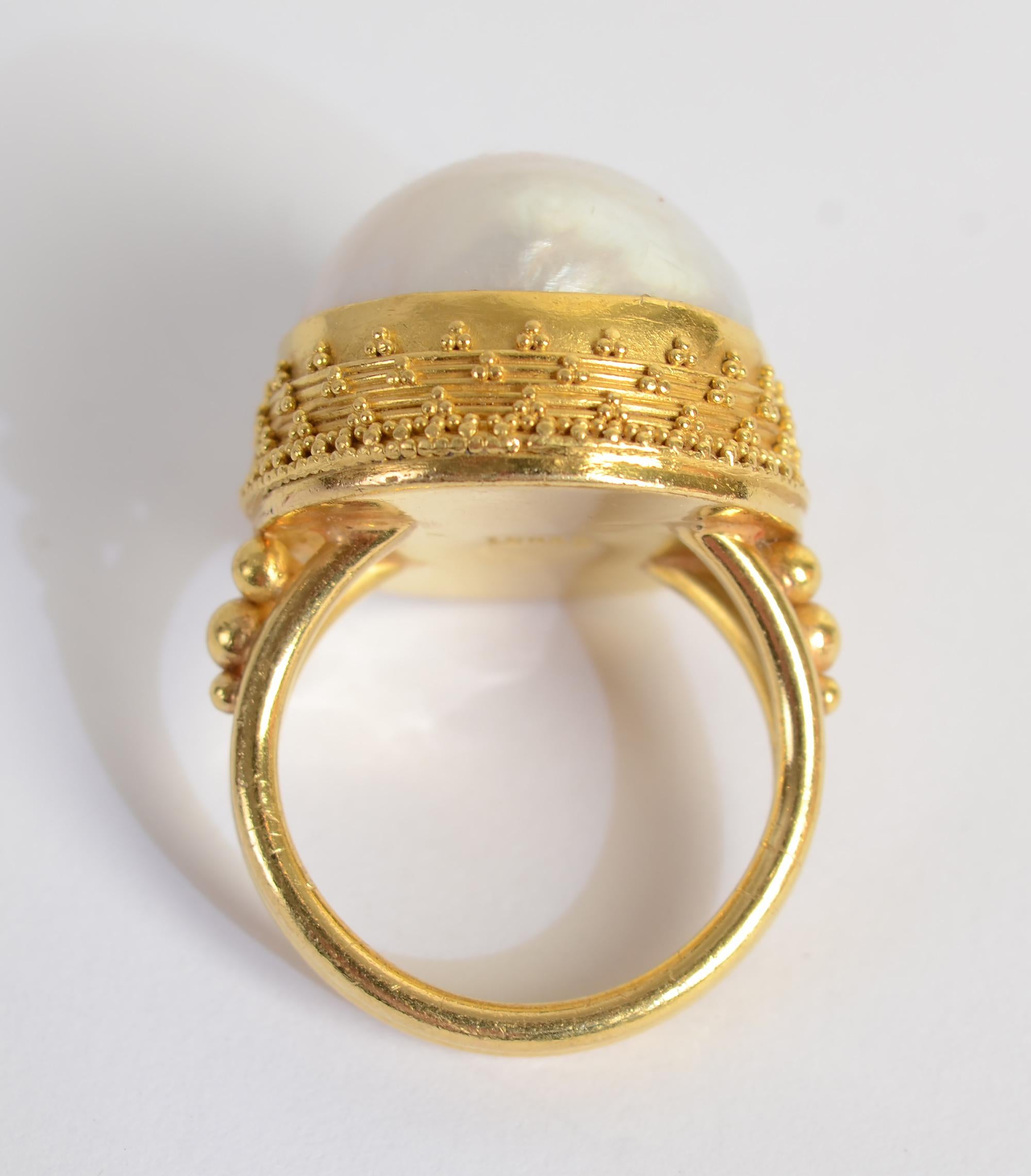 Imposing gold ring by Luna Felix featuring a 17 mm round South Sea pearl. The stone is surrounded by a multi-tier bezel with banding and extraordinarily fine granulation.
Much of Felix's work utilizes Etruscan granulation. She has been designing