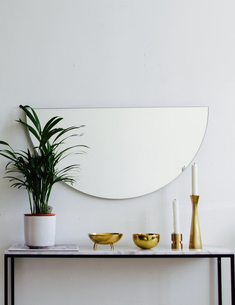 Original and minimalist half-moon frameless mirror with a floating effect. Quality design that ensures the mirror sits perfectly parallel to the wall. Designed and made in London, UK. 

Each piece is fitted with professional plates that allow for an