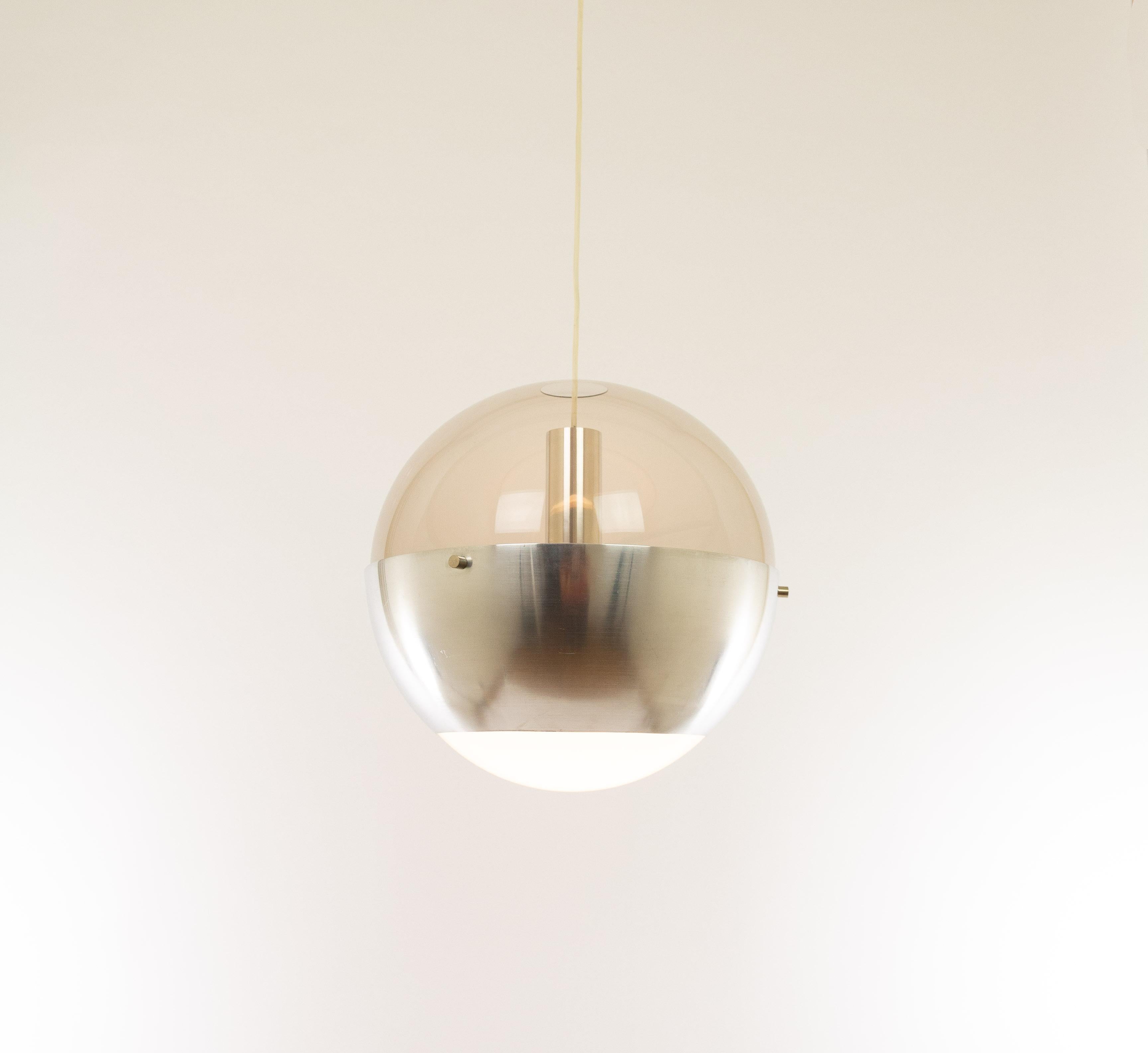 Rare pendant Luna designed by H. Fillekes for the Dutch company Artiforte, 1950s.

The lamp is made of a matted nickel ring with a Perspex top and a white opaline bottom. This special construction creates a beautiful light effect when switched