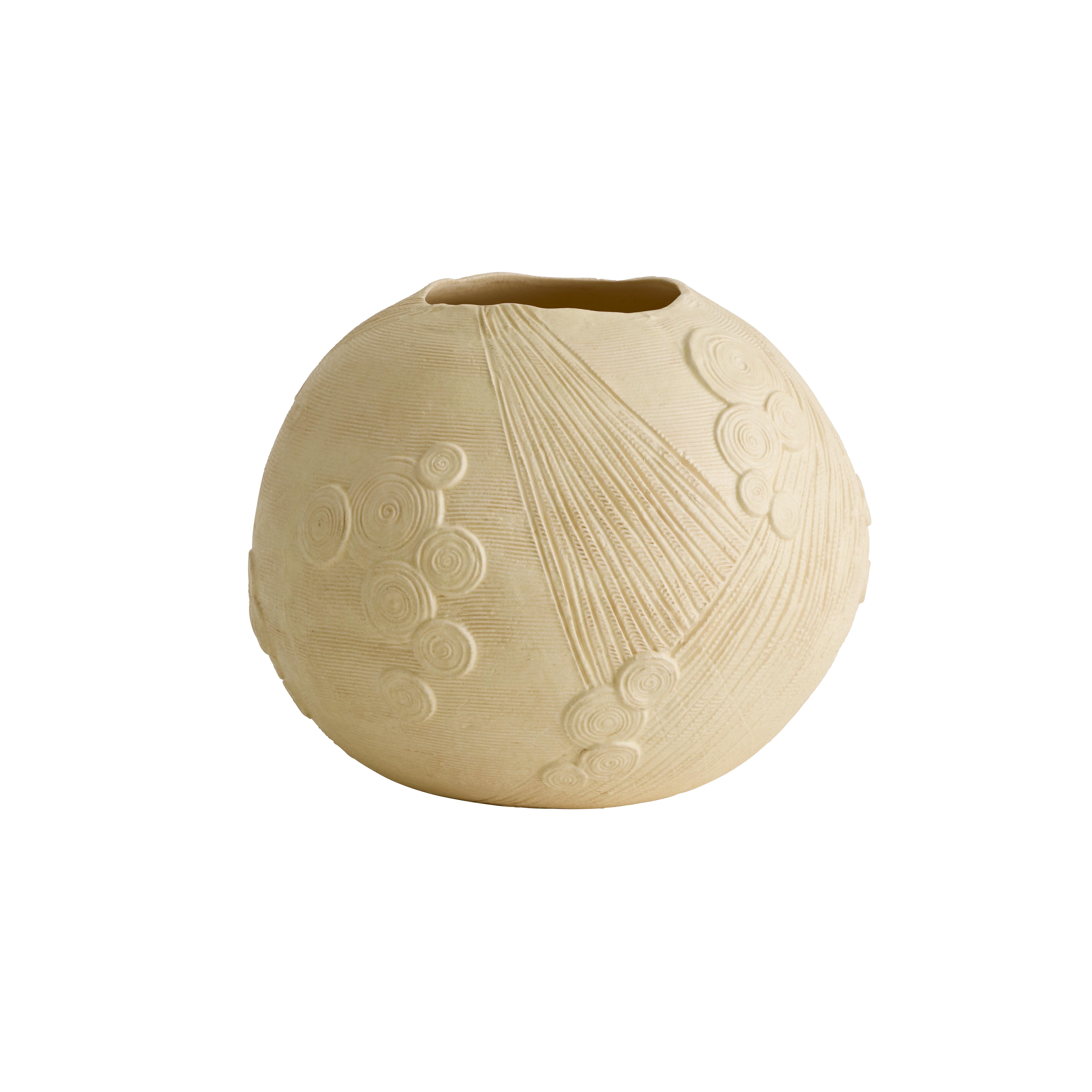 Le vase LUNA présente des motifs complexes, sculptés à la main, représentant les cieux, interprétés à travers une lentille géométrique. Son corps rond en porcelaine évoque la pleine lune, avec un bord volontairement irrégulier et une glaçure nacrée