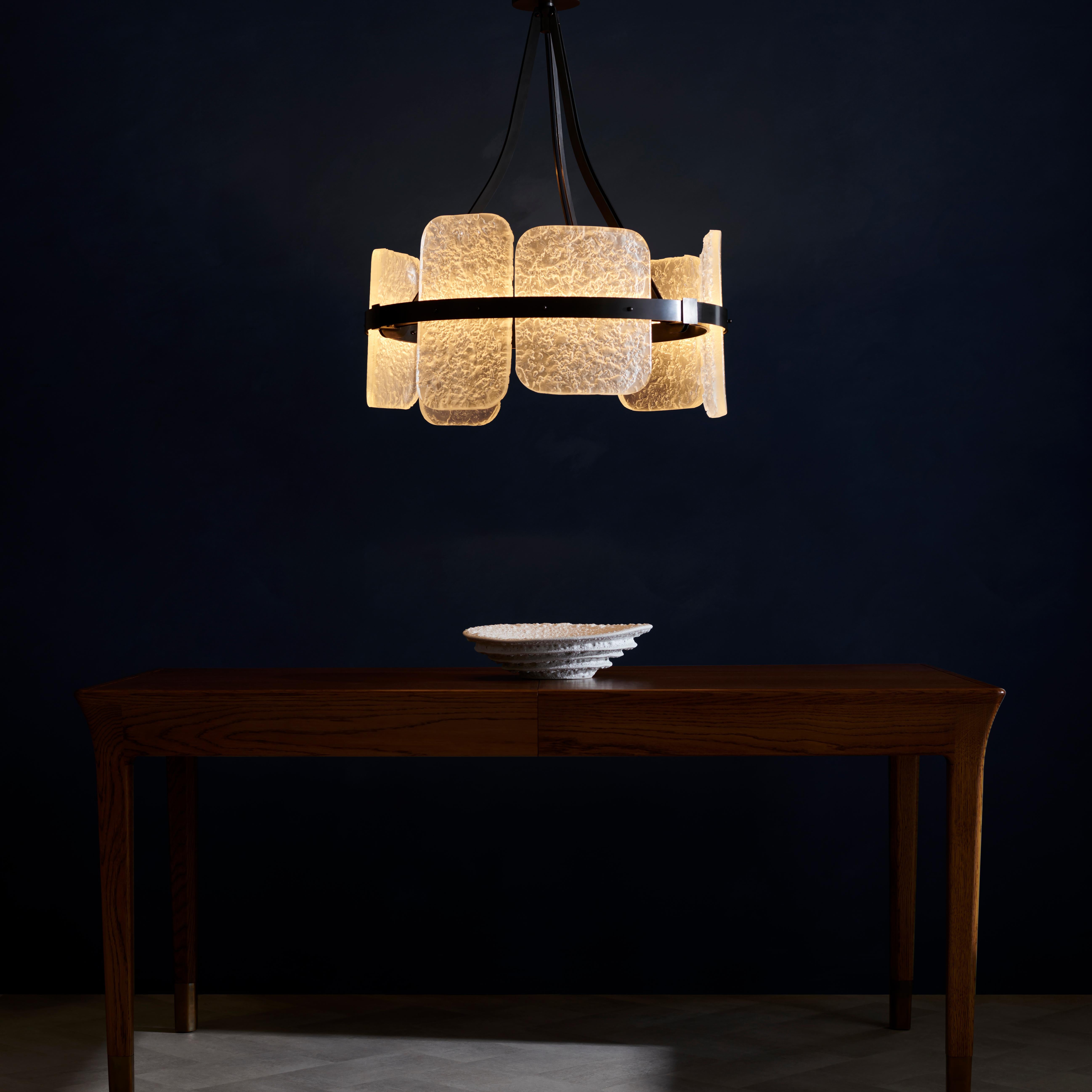 Presentamos la lámpara Lunar, una pieza refinada diseñada para cautivar. Inspirado en la superficie texturizada de la Luna, su cristal fundido a mano imita maravillosamente los cráteres lunares, creando un fascinante juego de luces y sombras.