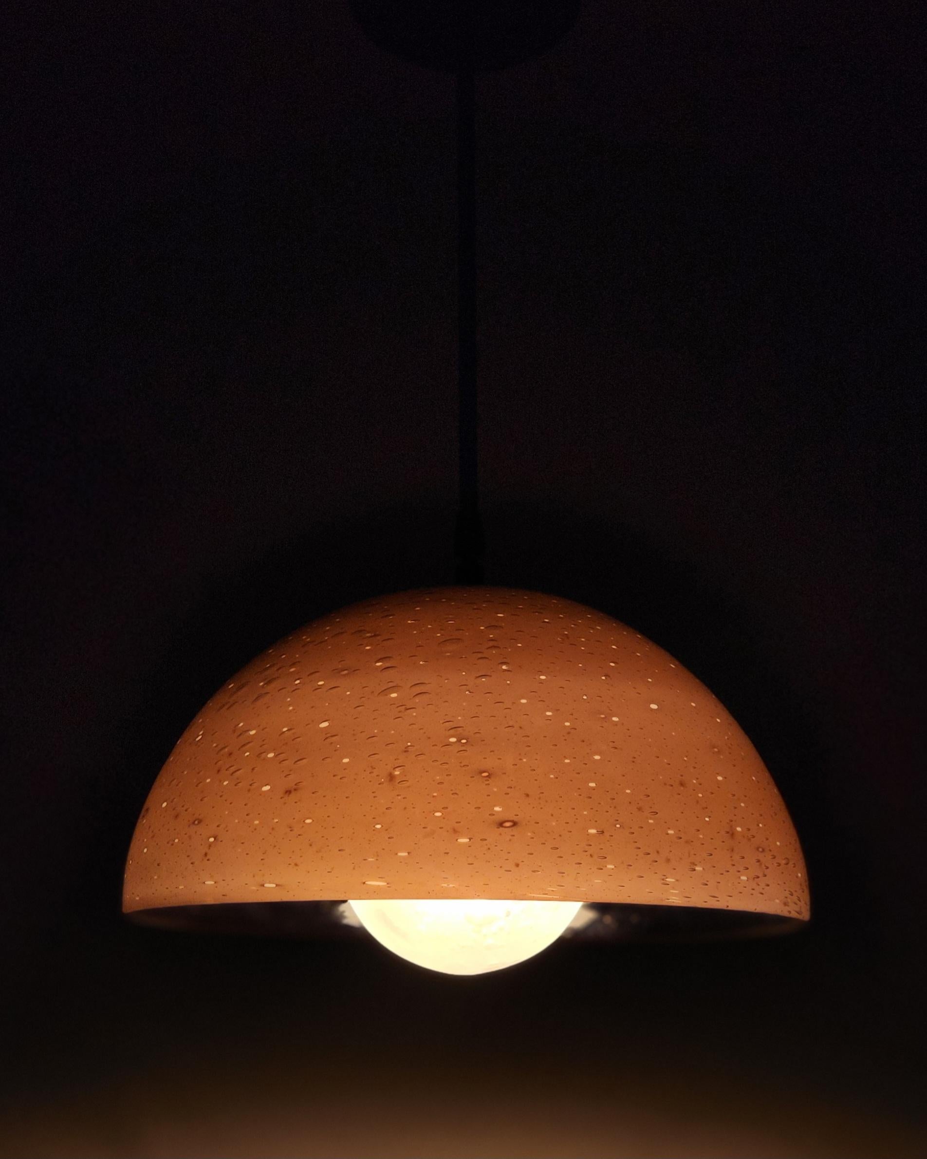 El Colgante Lunara explora la relación entre los cuerpos planetarios y la luna emparejando una semicúpula con un difusor esculpido a mano para crear una pieza que imita maravillosamente la interacción estelar de estas entidades celestes. Inspirado