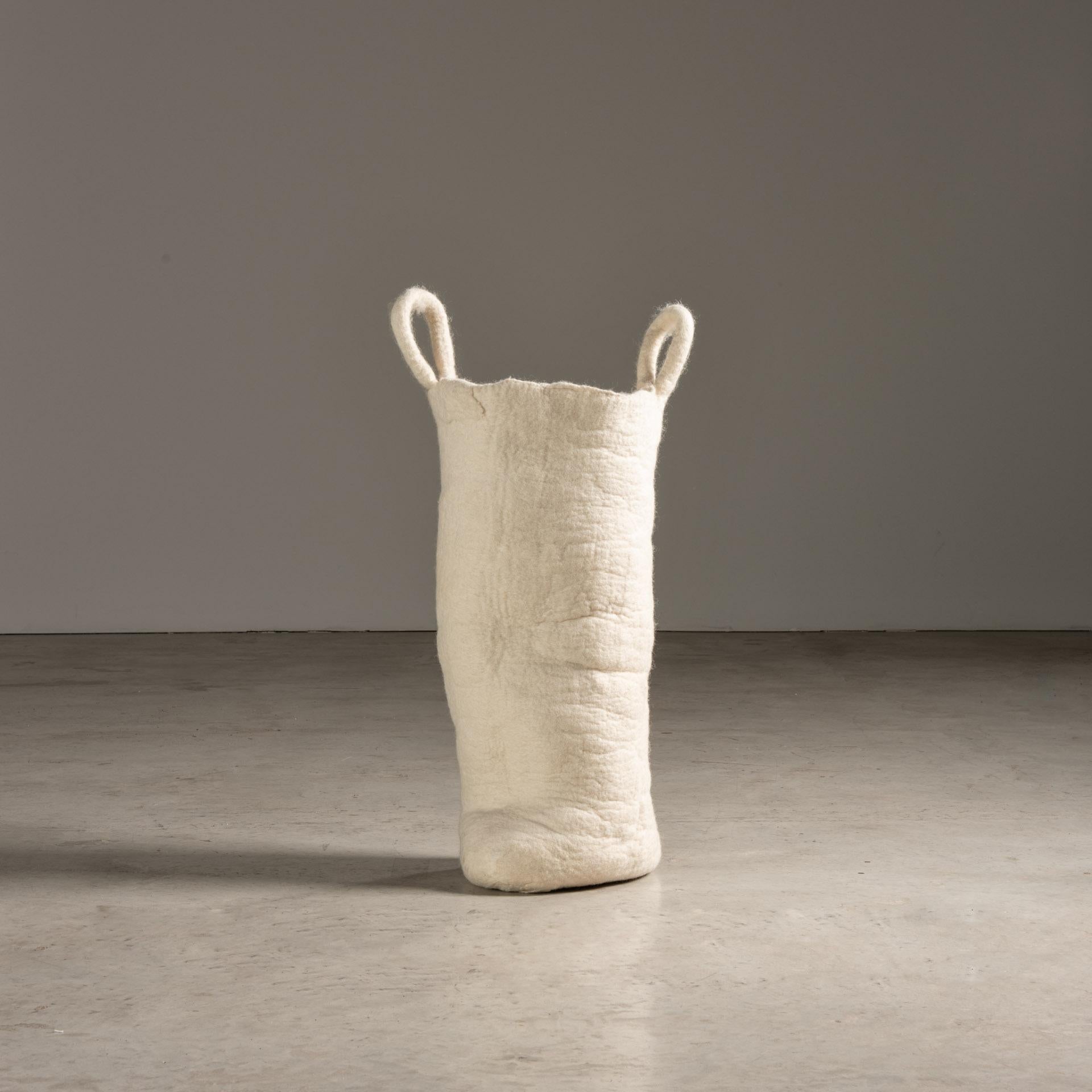Esta cesta de lana blanca de Inês Schertel es una exquisita ilustración del diseño moderno contemporáneo brasileño. La pieza está elaborada con métodos tradicionales, mostrando las cualidades orgánicas y lujosas de la lana de oveja.

La cesta se