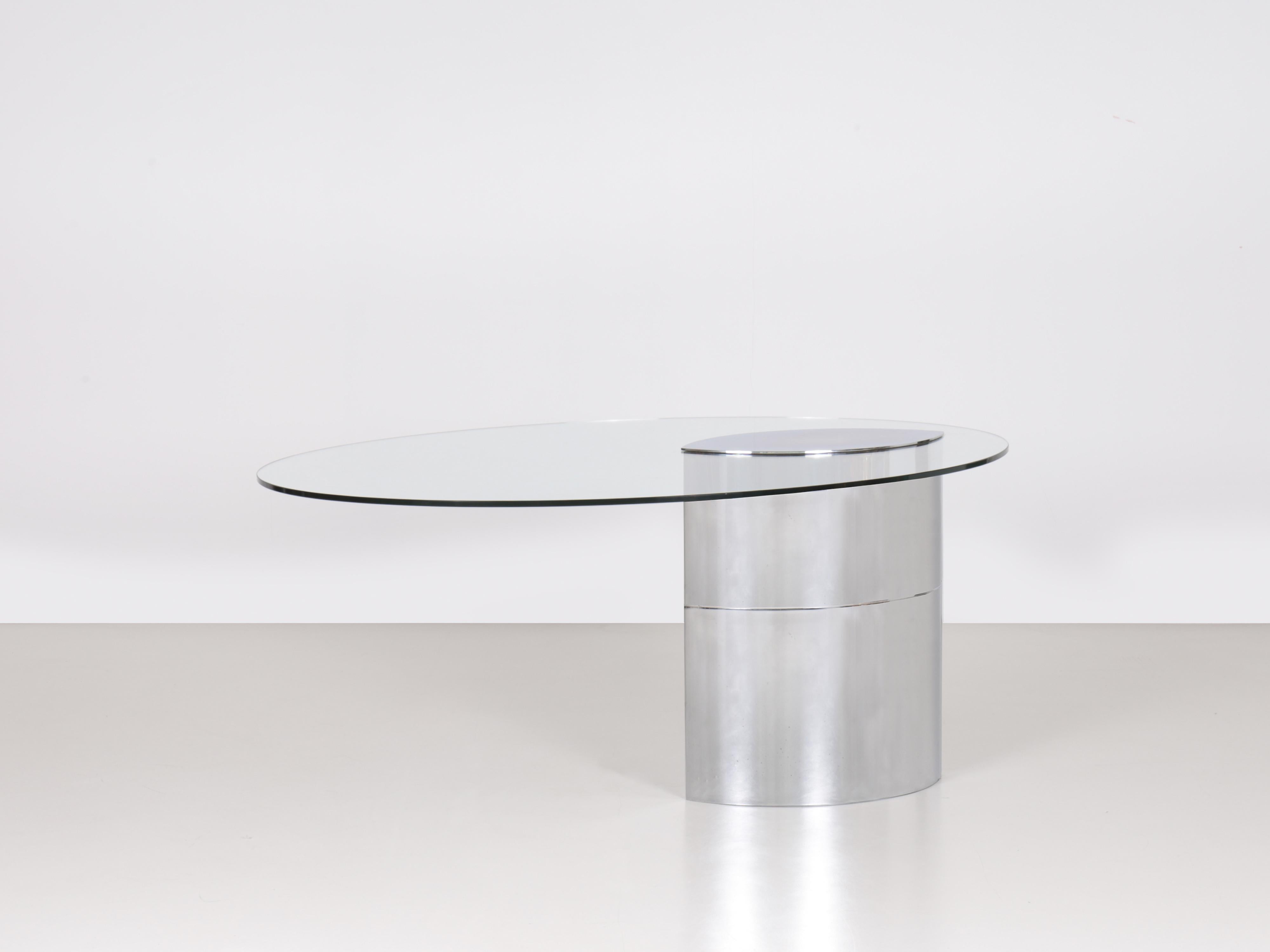 Tavolo Lunario disegnato da Cini Boeri, caratterizzato da una forma elegante e particolare. Piano in vetro ovale fissato alla base con una piastra in acciaio cromato. Base ellittica a doppia altezza in acciaio cromato, pesantemente pesata, che
