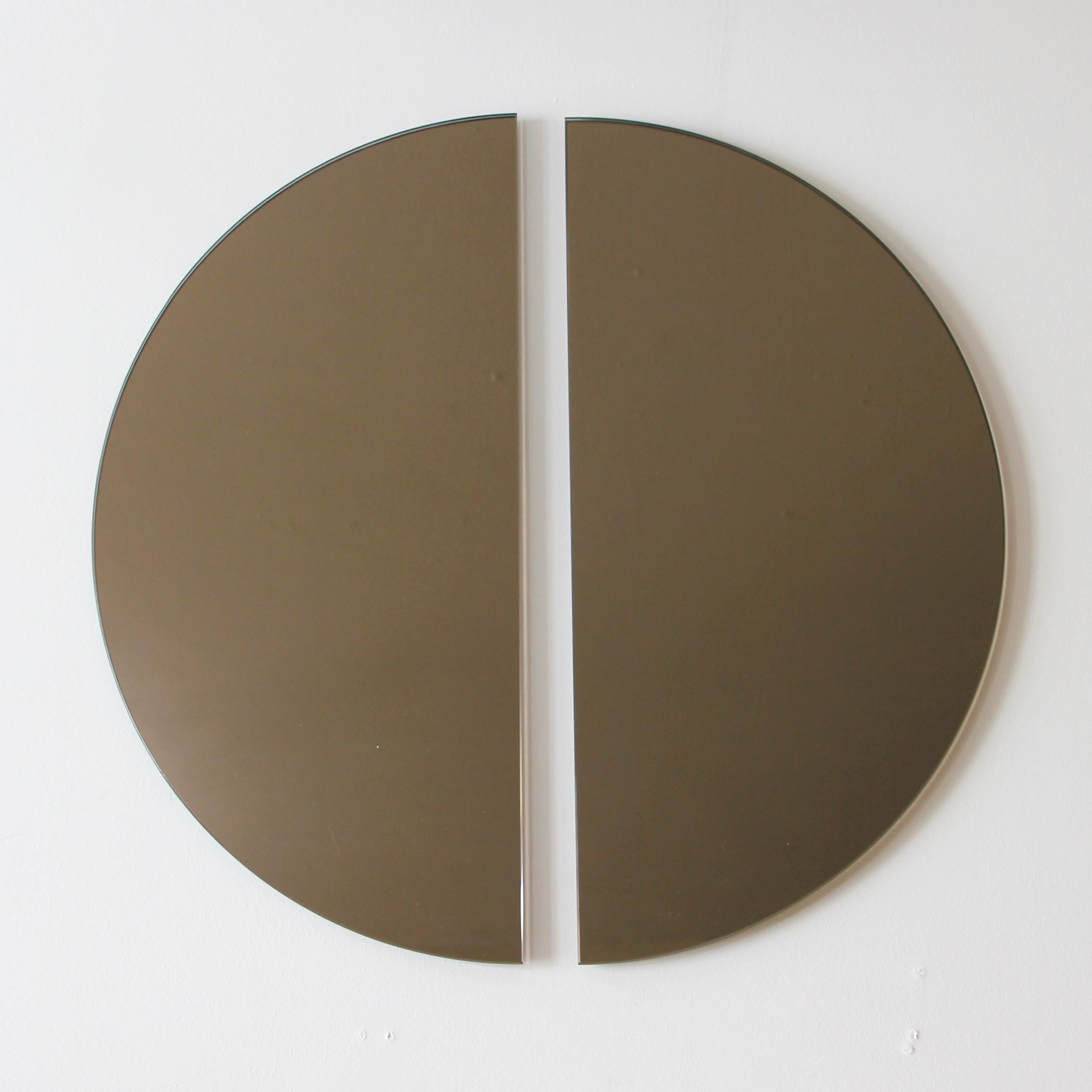 Original and minimalist half-moon bronze tinted frameless mirror with a floating effect. Quality design that ensures the mirror sits perfectly parallel to the wall. Designed and made in London, UK. 

Each piece is fitted with professional plates
