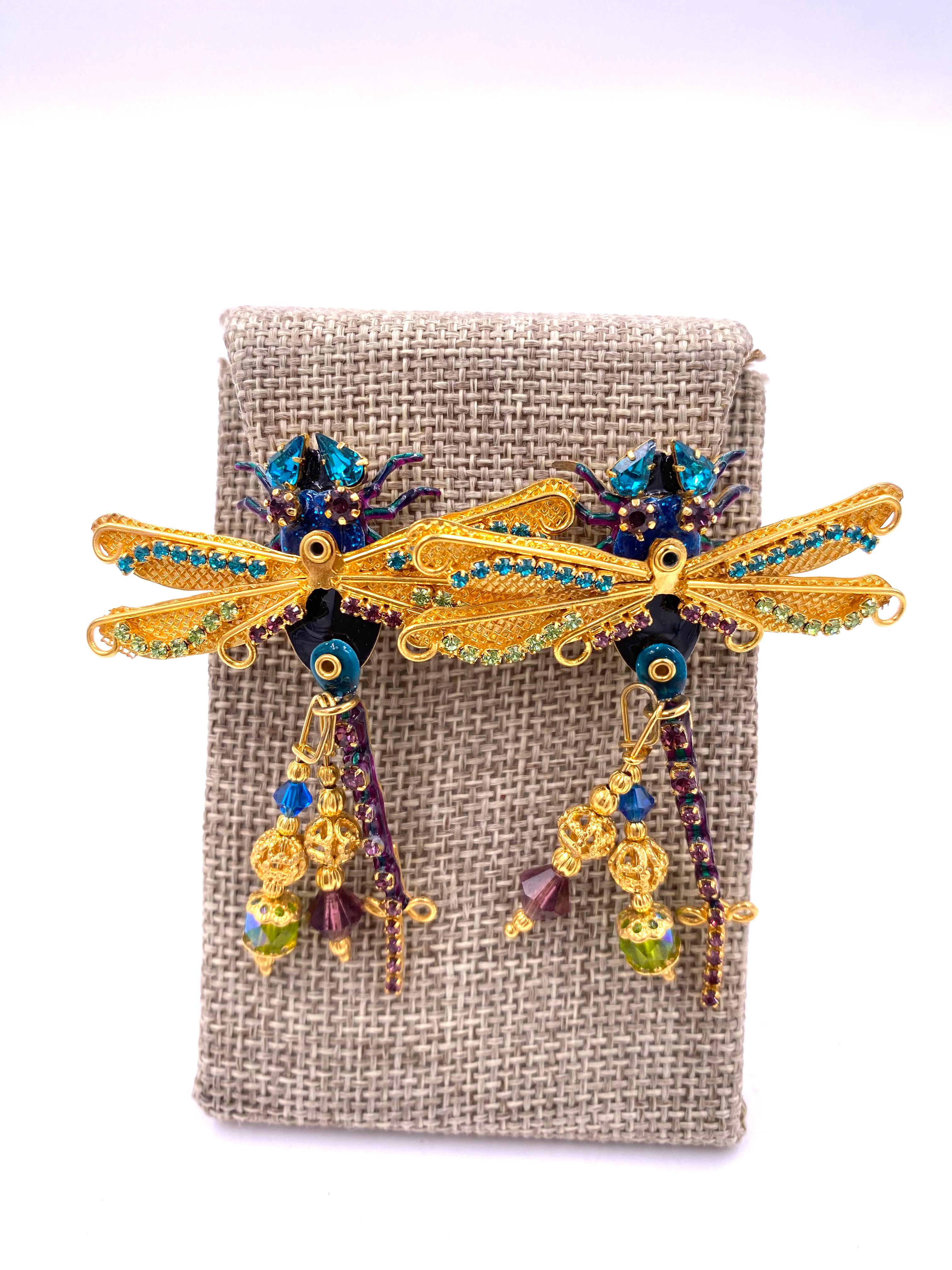 Indulge in the splendor of Lunch at the Ritz earrings, featuring striking damselflies with vibrant shades of purple, green, and blue. Adorned with dazzling rhinestones and intricate beading, these earrings are a luxurious addition to any collection.