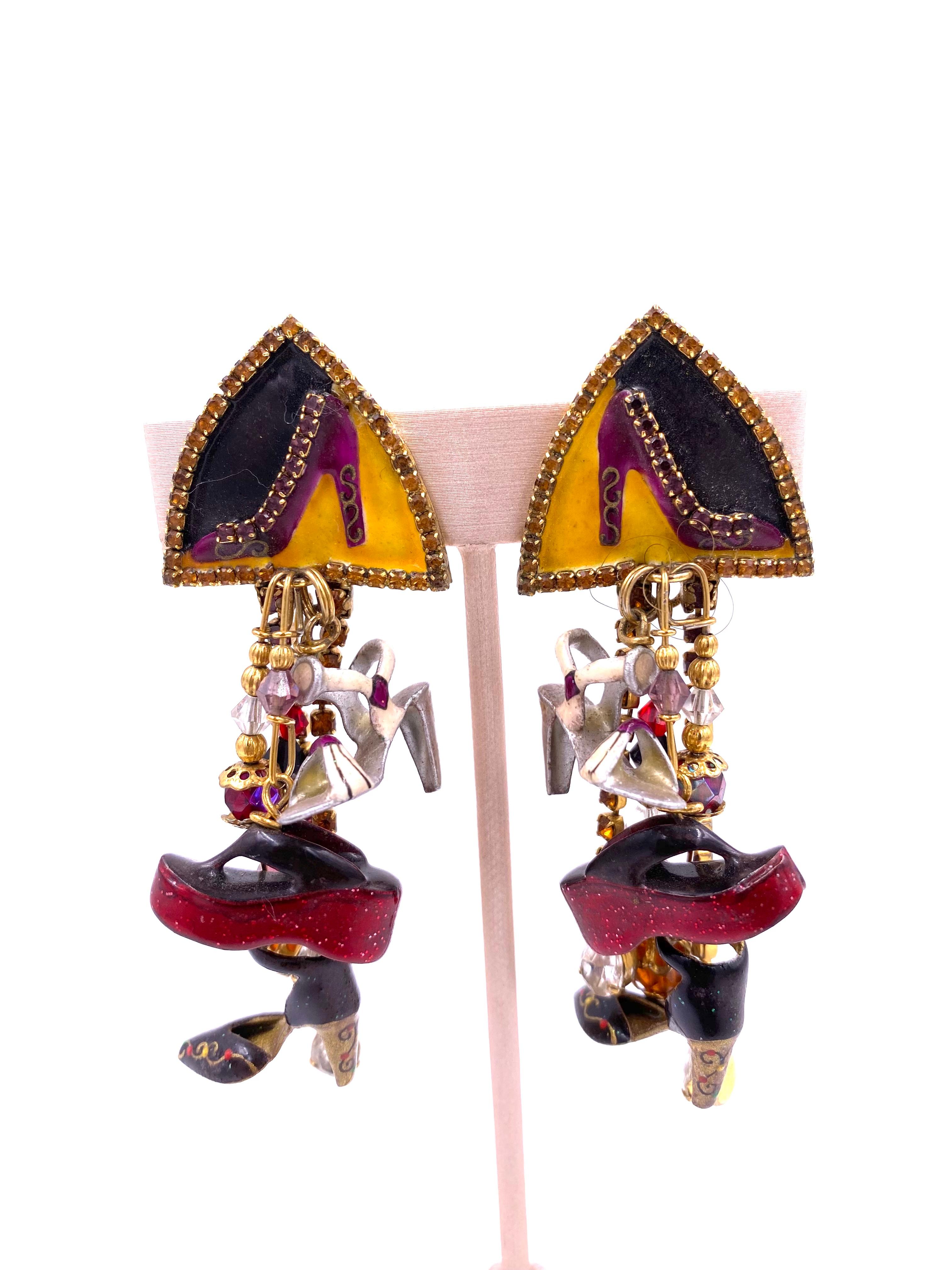These whimsical earrings by Lunch at The Ritz feature miniature shoe designs including platforms and pumps, adorned with gold and multicolored beads. Add a touch of fun and fashionable flair to any outfit with these unique accessories.

**ALL OF OUR
