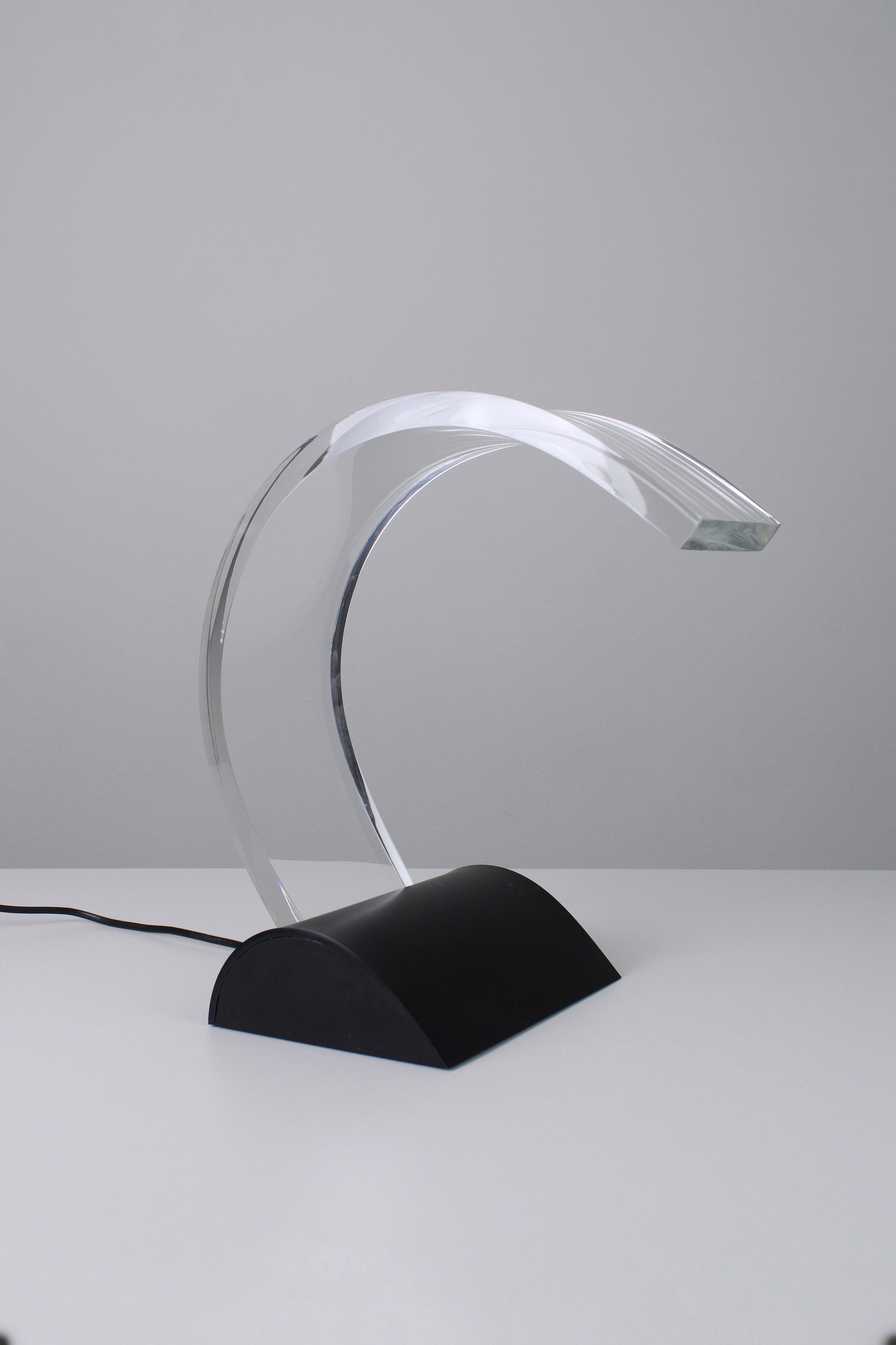 Lune desk lamp. Designed by Wout Wessemius in 1982. The design of this lamp consists of a large acrylic arc. In the base is a light that shines all the way through to the end of the arc on the surface. Unique lamp in overall good condition. There