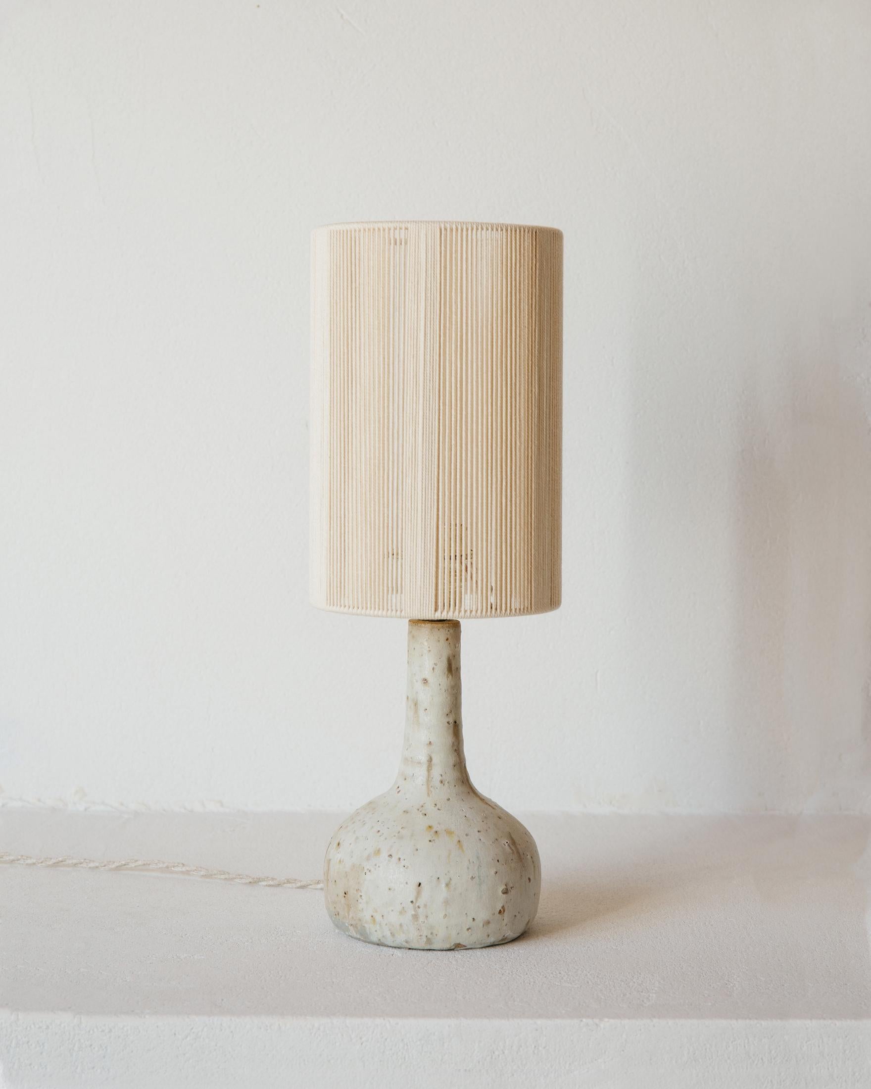 Lampe de table Lune en céramique blanc crème mat par Grès Éditions
Pièce unique.
Dimensions : Abat-jour : Ø 16 x H 23 cm.
Base : H 20 cm.
MATERIAL : Coton écru et céramique.
Poids : 1,2 kg.

Système électrique : câble électrique tissé en lin