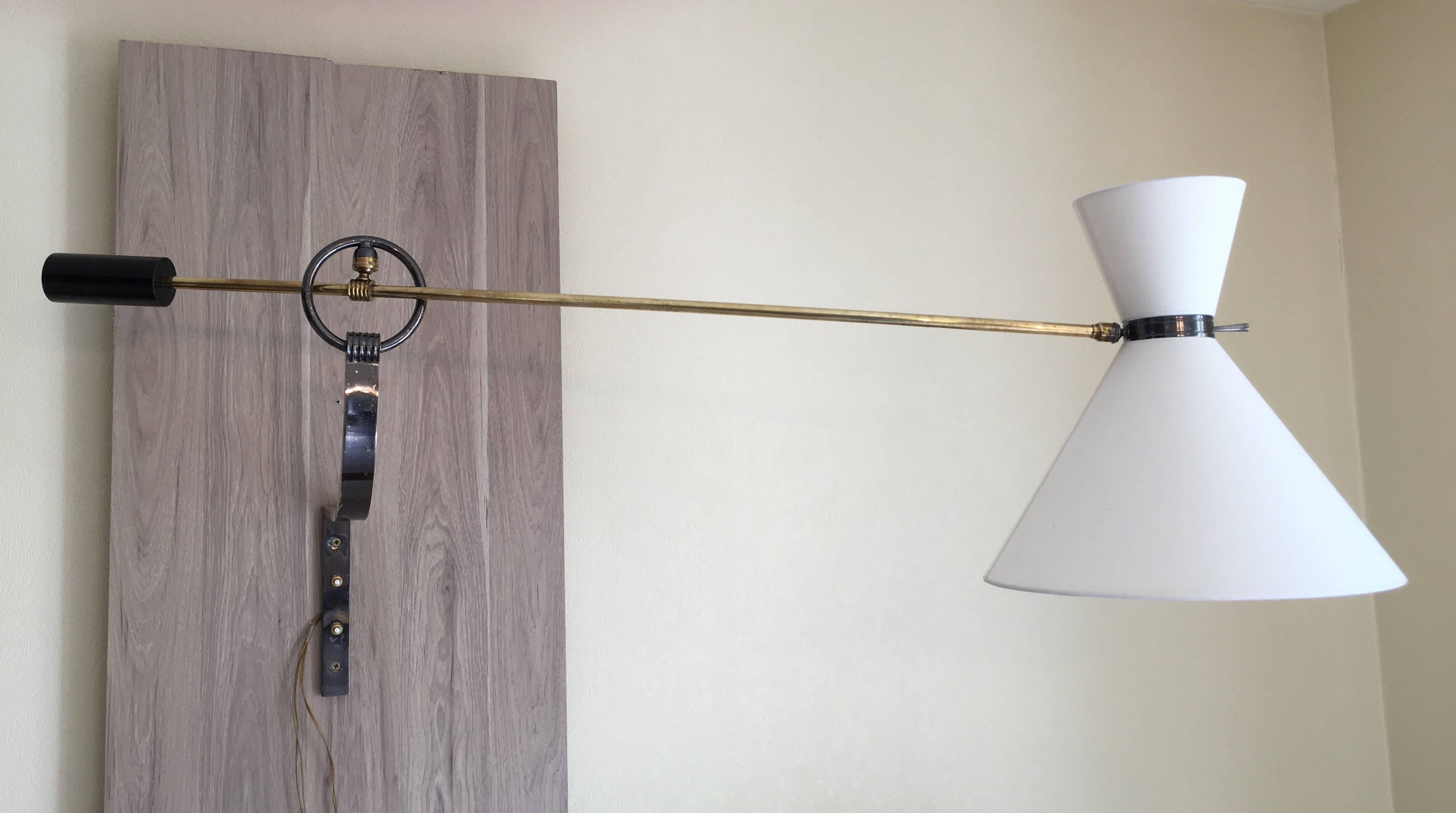 French counterbalance wall sconce designed by René Mathieu and edited by Lunel in 1950s
Massive gunmetal bronze bracket supports a ring. Two ball joint systems and a counterweight allow to adjust the brass long arm and the diabolo shades.
In perfect