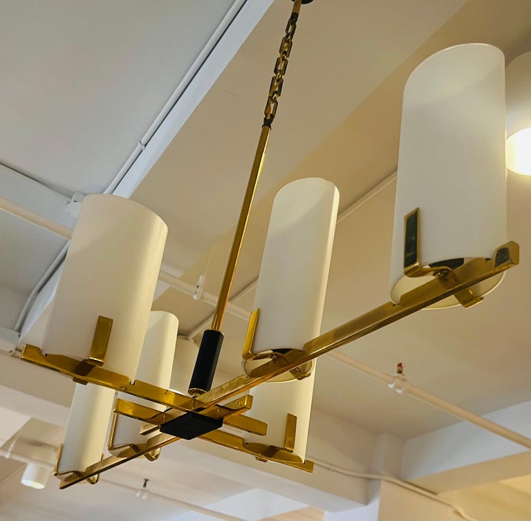 An original French modern six light polished brass and black enamel chandelier with white opaline ovoid tube glass shades. Made by the noted French lighting maker, Lunel. Rewired.