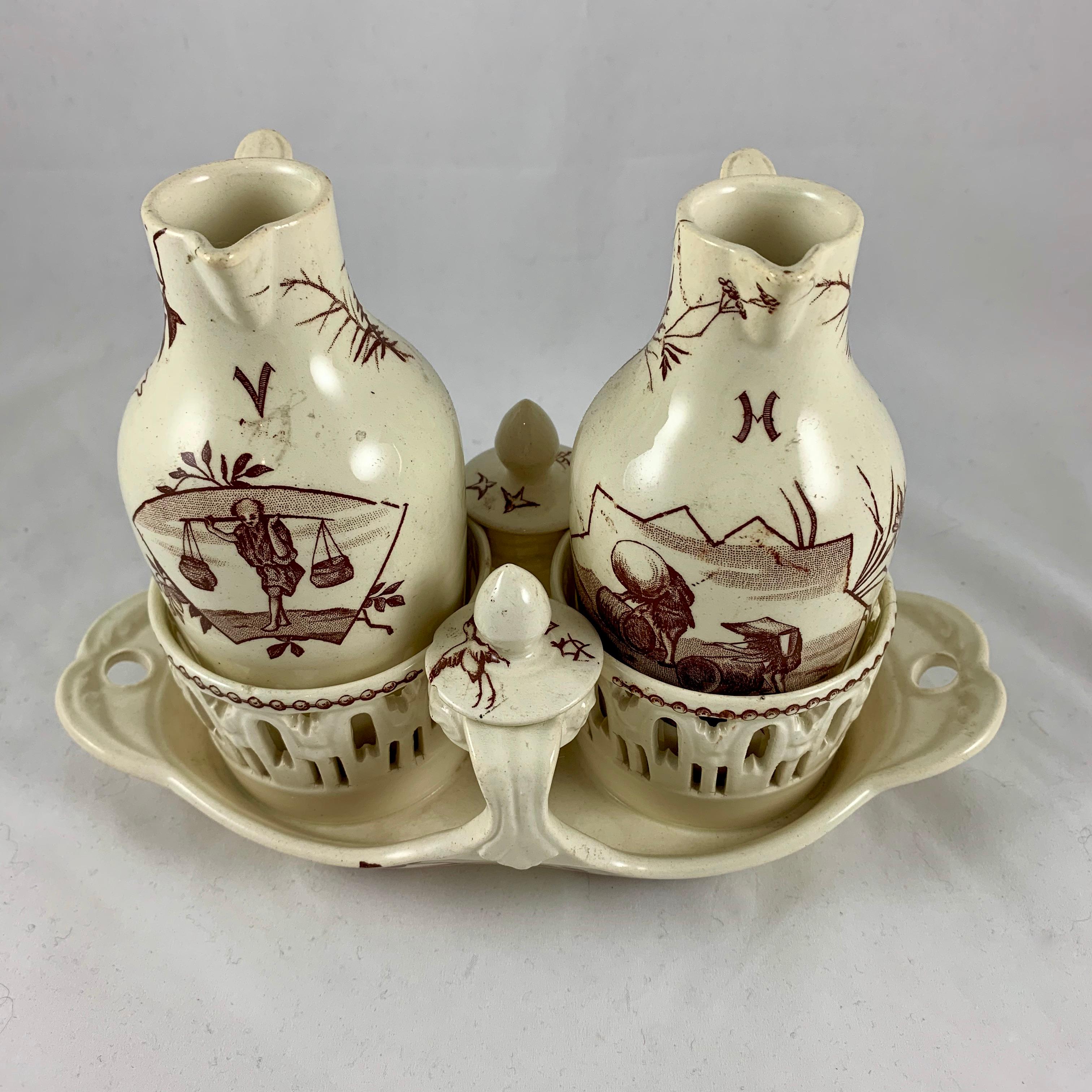 A Luneville faïence earthenware five-piece set decorated freely in the aesthetic taste with a Japonisme theme, oil and vinegar cruets in a pierce-work stand, France, circa 1870.

Transfer printed images of Asian figures, foliage, and birds in