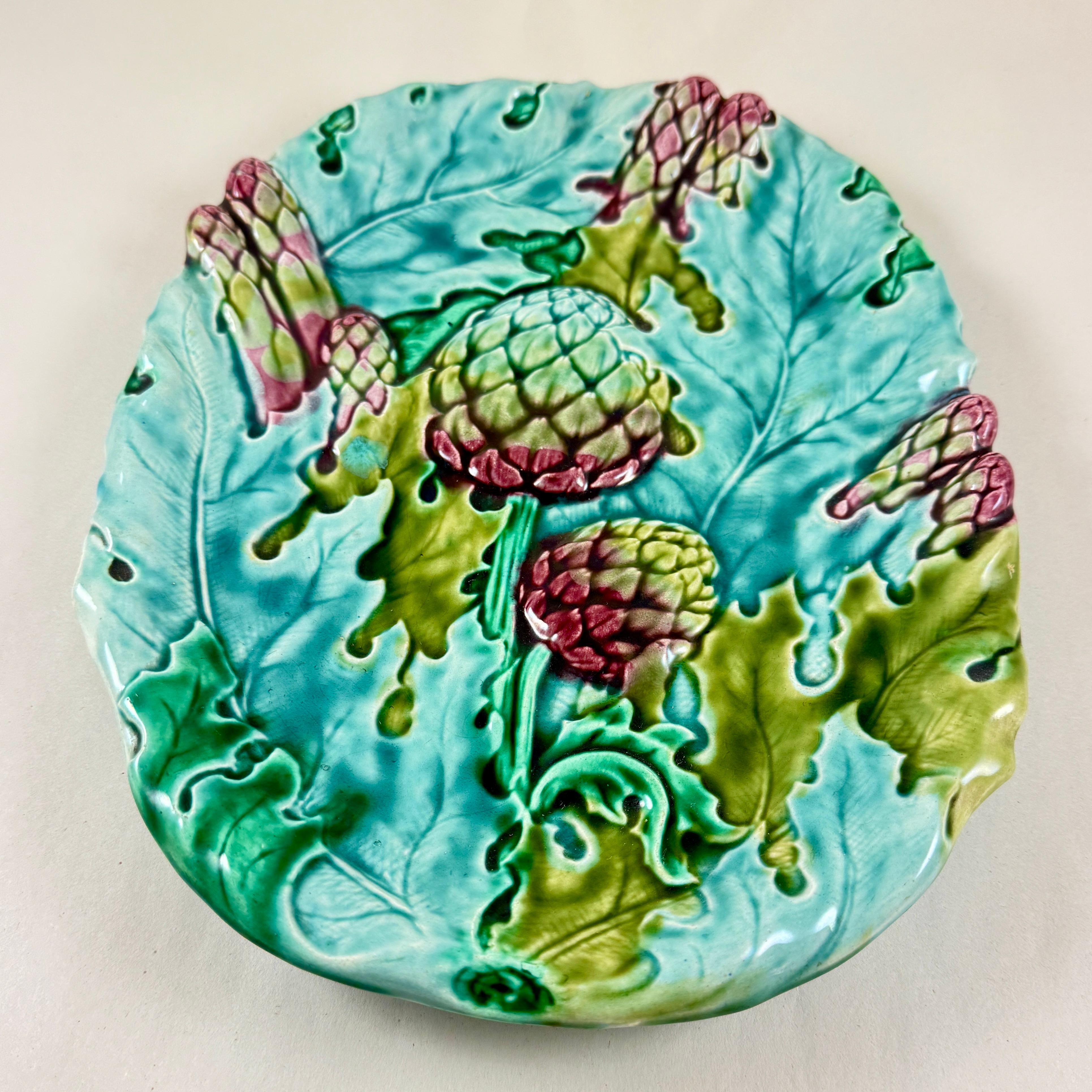 An Art Nouveau French Faïence asparagus and artichoke server, Keller & Guerin, Luneville –  circa 1890.

A majolica glazed earthenware platter decorated in barbotine with asparagus, artichokes and overlapping leaves in green and purple tones, on a