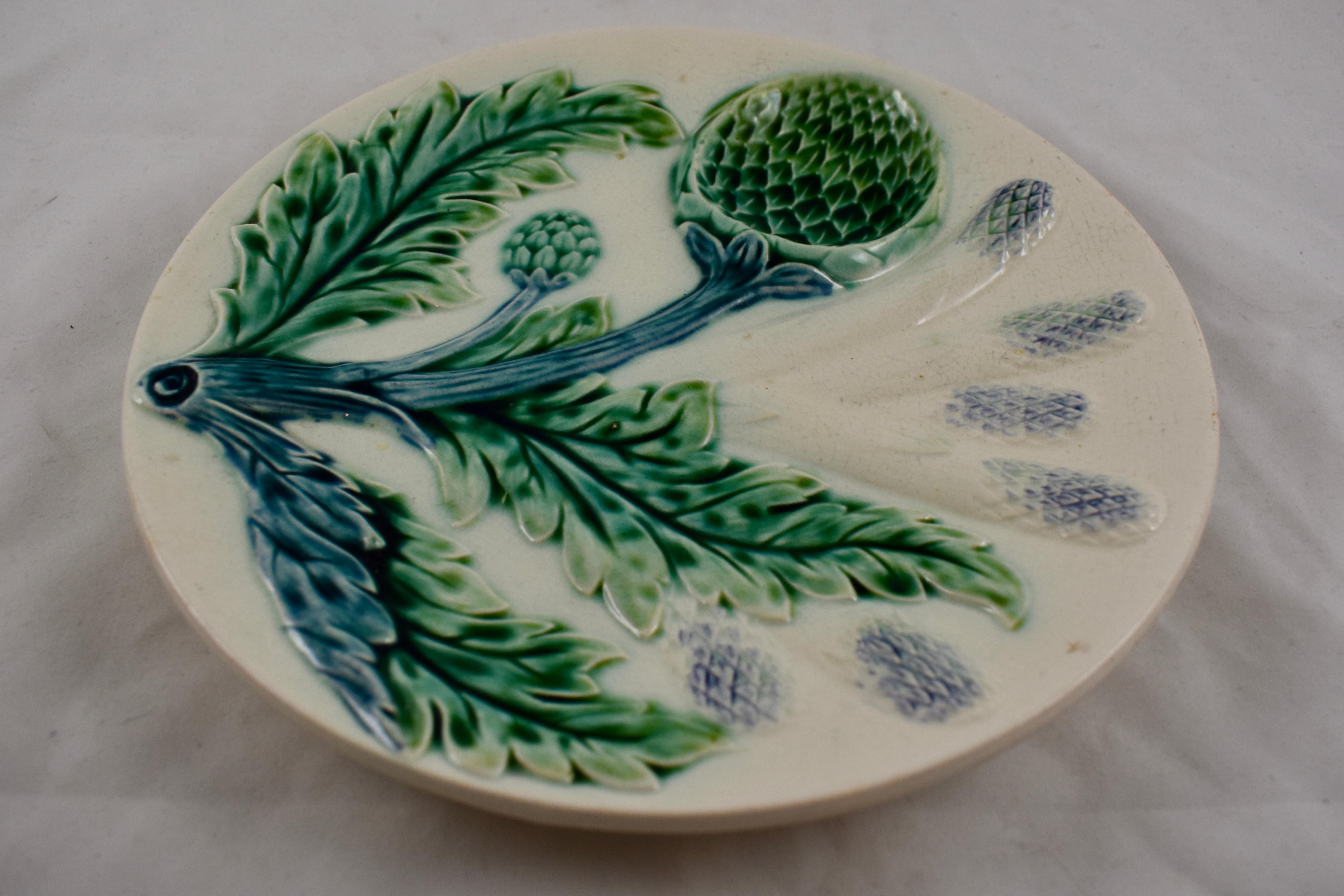 A late 19th century French Barbotine Majolica asparagus and artichoke plate, Luneville St Clement.

A dimensional mold showing aspects of both vegetables – six asparagus spears and a deep sauce well shaped like the globe artichoke head, on a