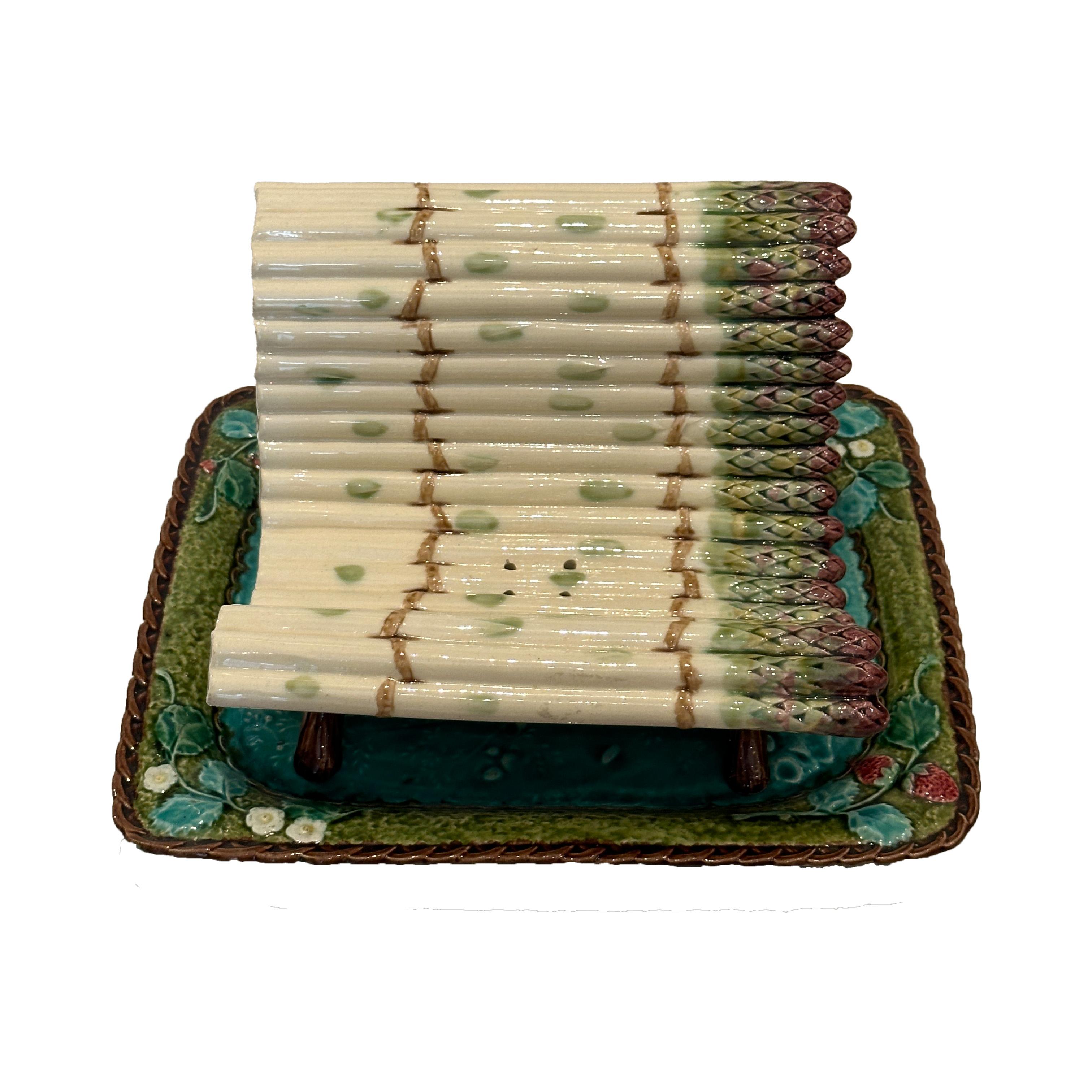 Cet ensemble exquis comprend un égouttoir à asperges et une assiette assortie, fabriqués en majolique française à la fin du XIXe siècle. L'égouttoir est conçu en forme de banc, avec une rangée de pointes d'asperges reposant sur des pieds en forme de