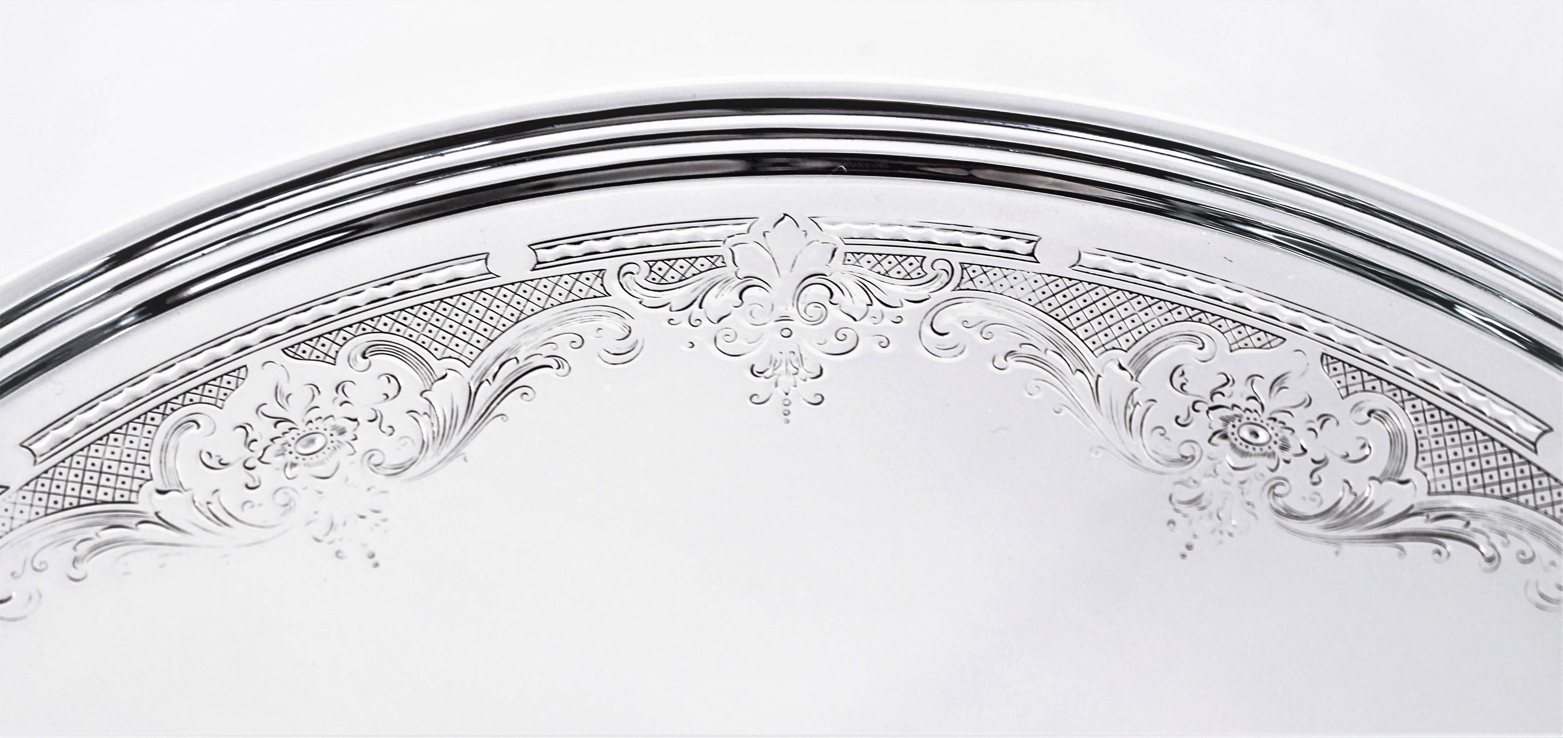 The perfect size for a pie or cake, its flat surface is ideal for serving. Soft etching of flowers, garlands and latticework encircle the rim. In the center, a cartouche awaits your monogram. This piece is not weighted.