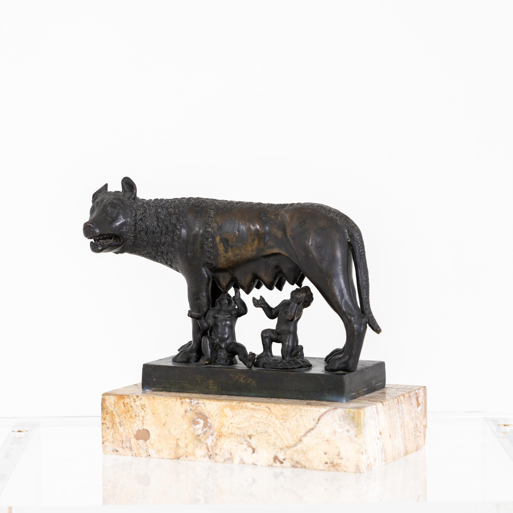 Small bronze of wolf mother with Romulus and Remus on stone base.