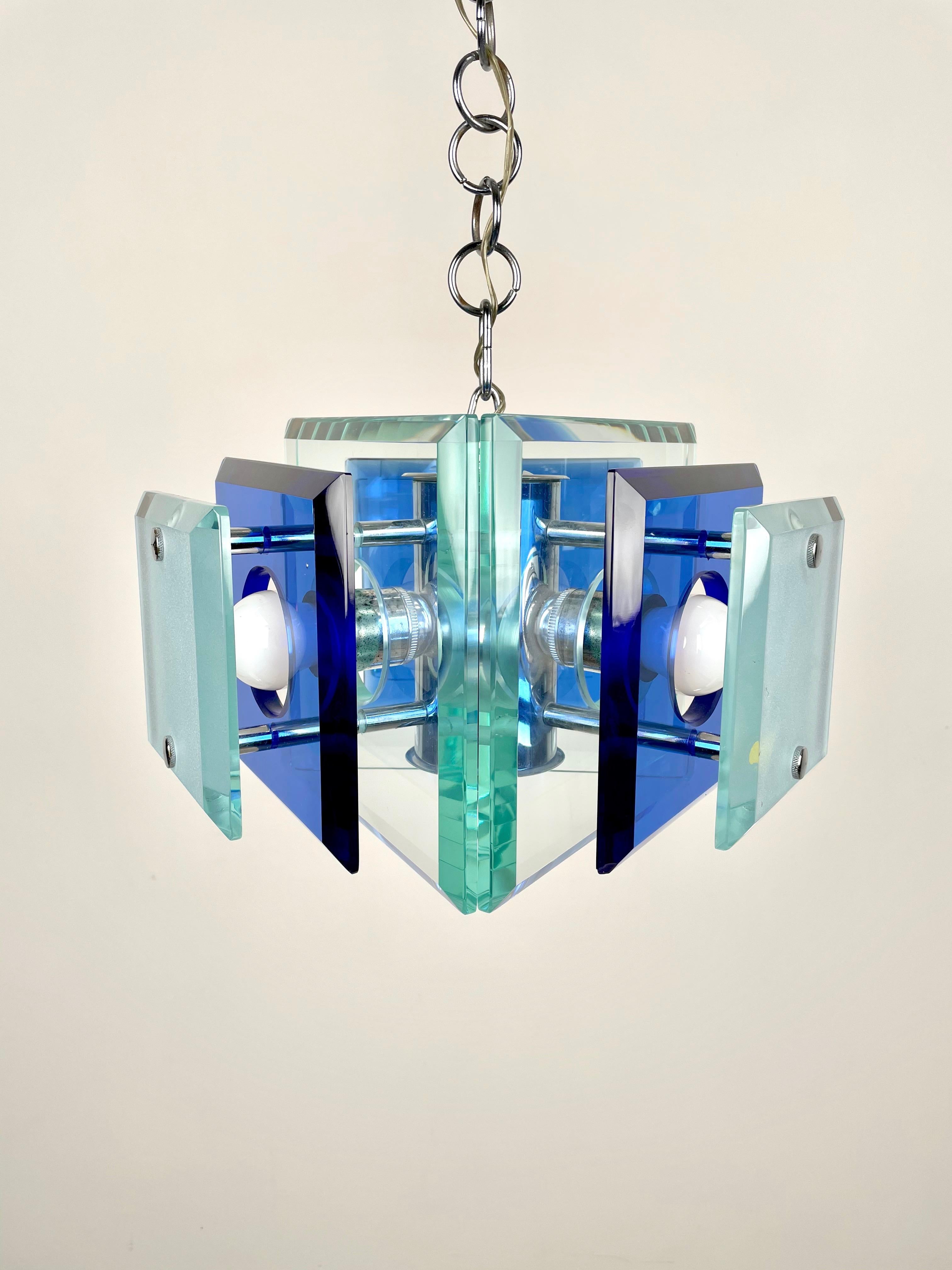 This is a three-light chandelier in chrome and blue and green heavy glass by Lupi Cristal Luxor, Italy, 1970s. 
The original label is still attached as shown in photos. 

Height with pendant: 80 cm. 
Height without pendant: 24 cm.