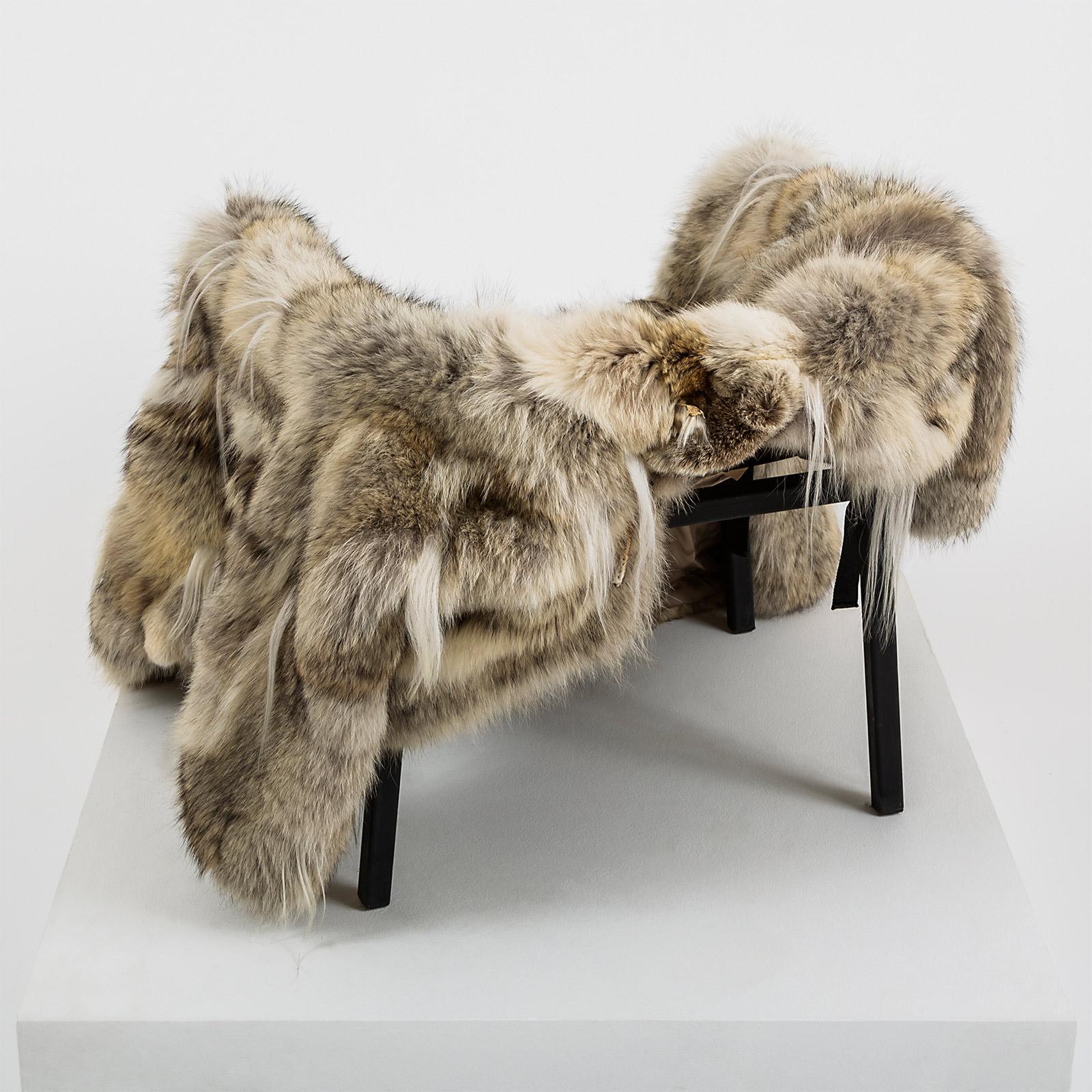 Ein schwarzer Stahlrahmen für einen Stuhl. Ein Pelzmantel (Wolf, Ziege) in Größe M/ L. Der Mantel ist mit Riemen versehen, die ihn in einen Sitz verwandeln, wodurch der Stuhl funktionell und vollständig wird.

Materialien: Stahlgestell und