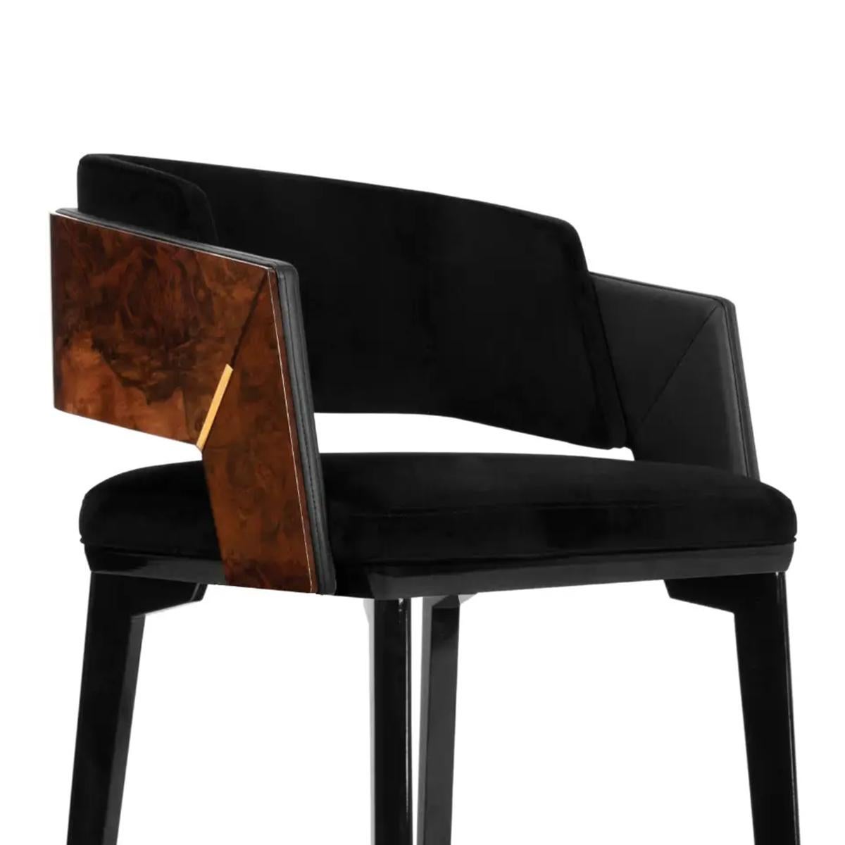 Bar stool Lupus with structure in solid walnut,
seat and back upholstered and covered with
black velvet fabric, inside armrests covered with
black genuine leather and outside armrests and 
back covered with varnished walnut root. Details
and
