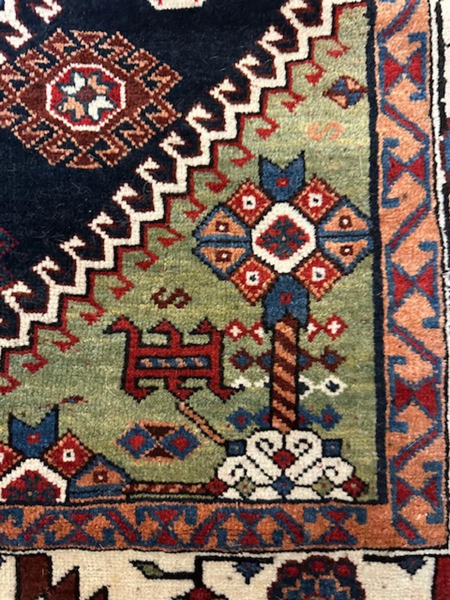 Luri rug from south west Persia (Iran)

Age: circa 1875

Size: 8′.8″x5′.3″ (264×160 cm)

The navy field is mostly covered by a pole medallion of three large hooked red and blue diamonds,each centered by an ivory rosette knot.On the sides of the