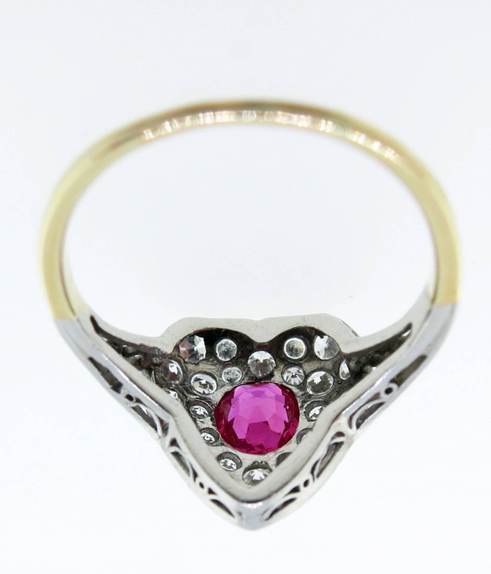 Romantic platinum top and 18kt. yellow gold shank heart shape ring circa 1910. The center is set with a gem color natural ruby weighing approx .60cts. surrounded with 27 old European cut diamonds totaling approx .70cts. The ring is size 4 1/4 and
