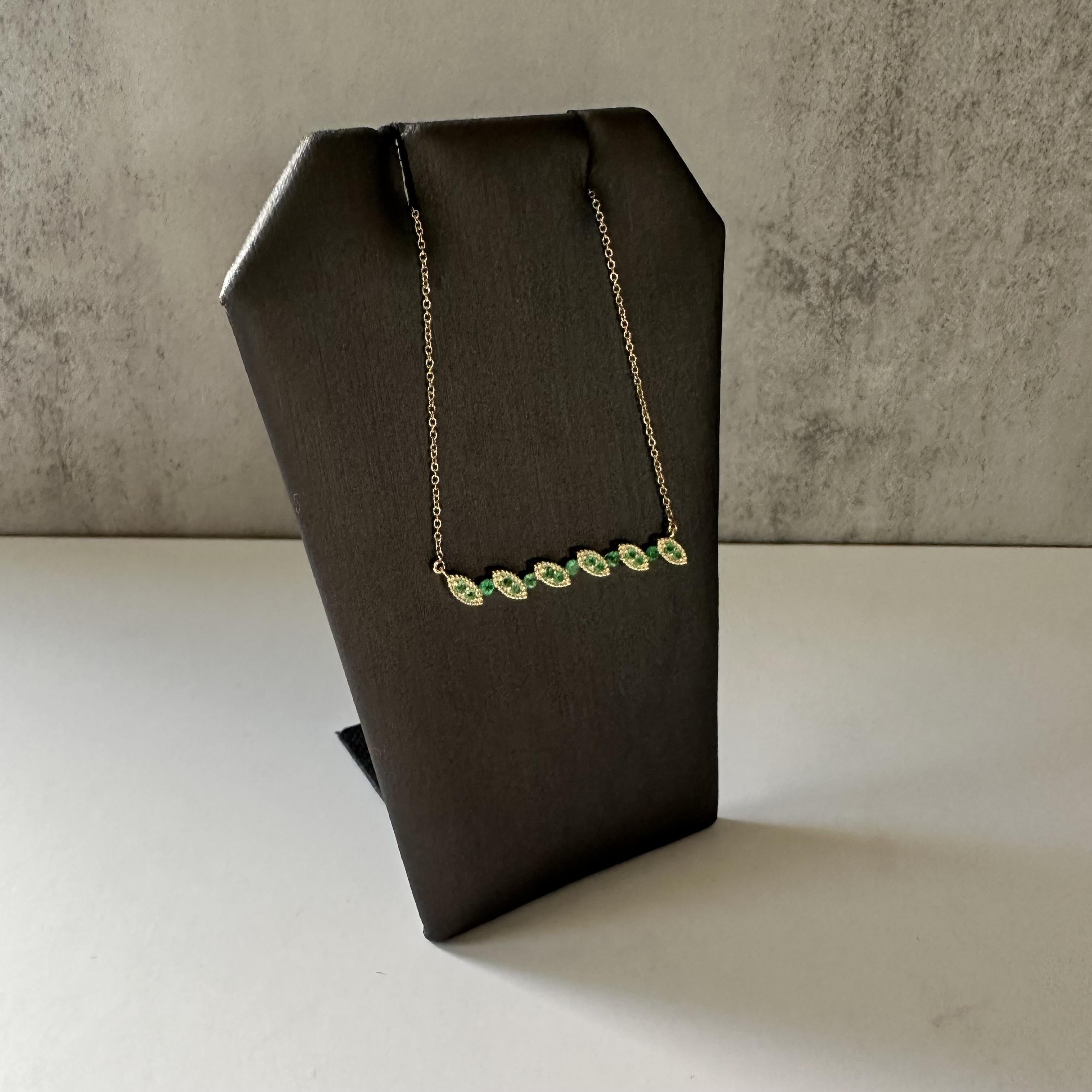 Discover the allure of this exquisite Emerald Necklace in 10k Yellow Gold. Featuring 0.3 carats of vibrant green round-cut emeralds, this piece offers a fresh and elegant design. The delicate arrangement of emeralds adds a touch of nature-inspired