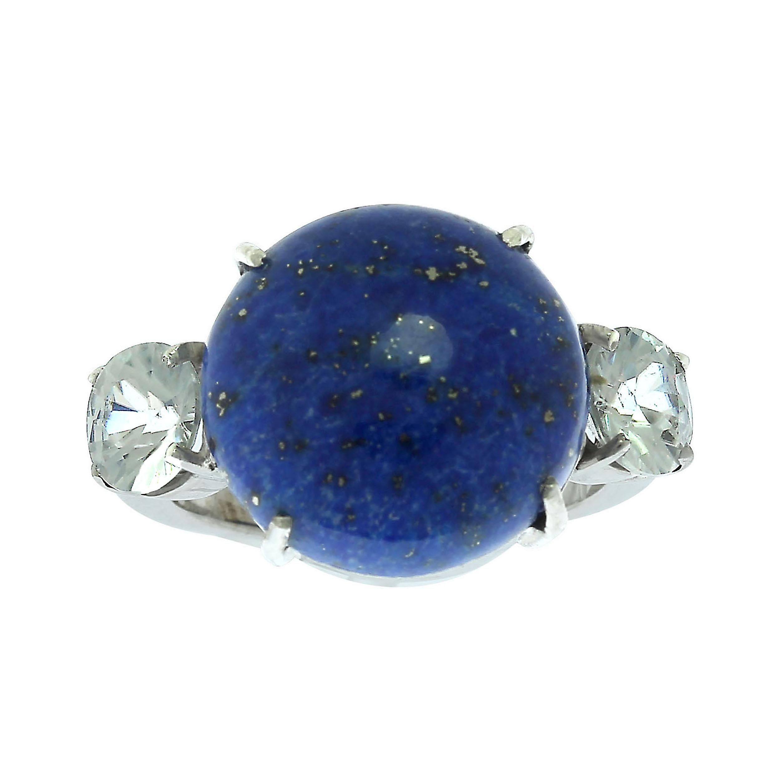Simplicity and Elegance combine to create this Lapis Lazuli and Cambodian Zircon unique Gemjunky ring.  This is a highly polished, 15 MM round Lapis Lazuli cabochon flanked by two glittering white round Cambodian Zircons. The hand made setting is