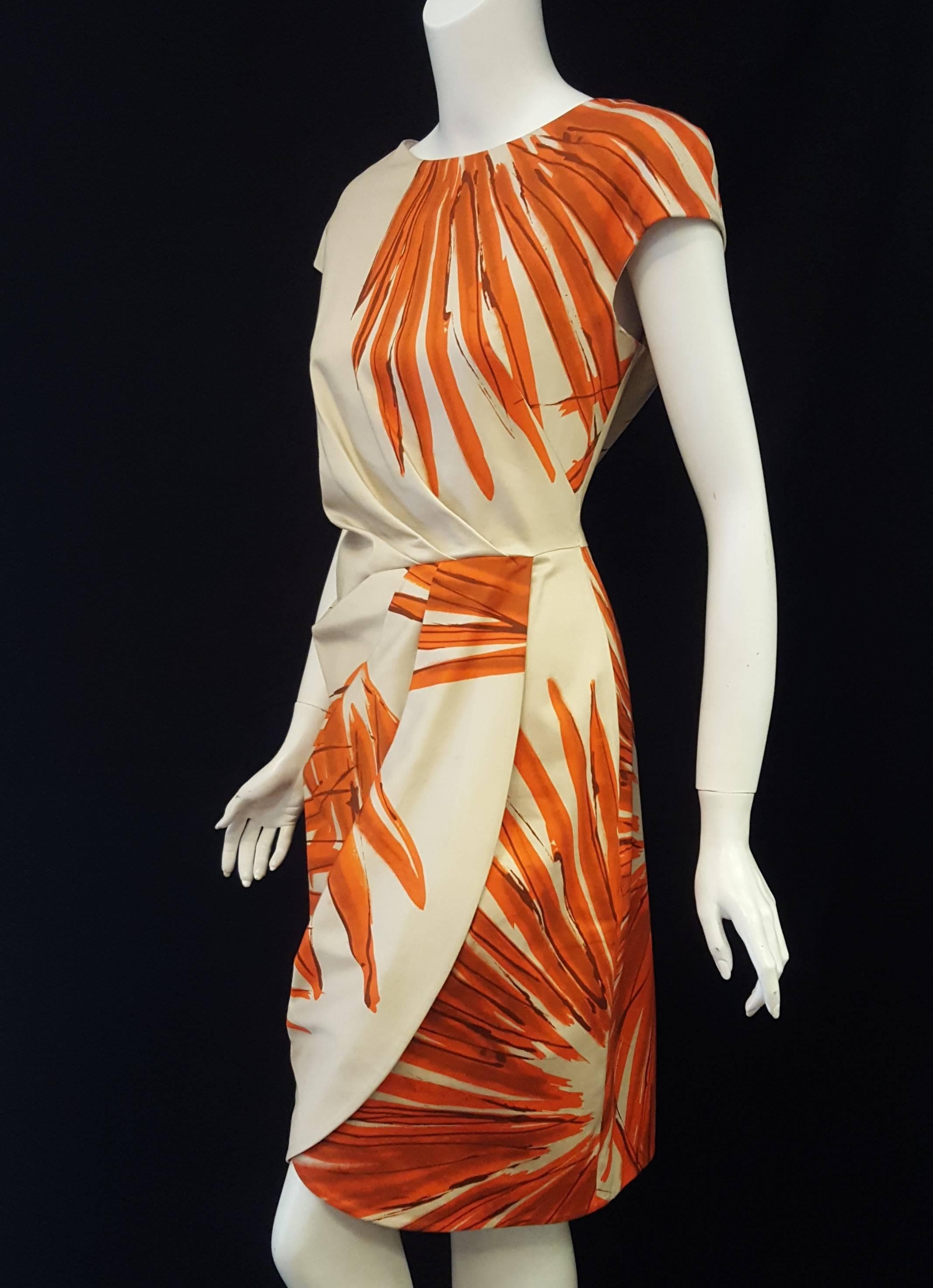This bold tropical print Lela Rose cotton blend dress features a gathered drape from shoulder to waist then from waist to hem.   The lower drape is not fitted or attached to the dress, it is open for a sexier look.  This dress has a round neck and