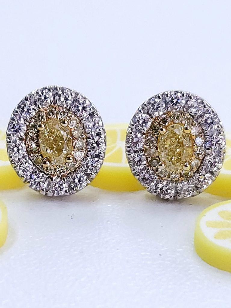 These Luscious Lemons offer a twist on the classic studs. These studs are made with Lemon Yellow Ovals with a Lemon Yellow Diamond Halo and a White Diamond Halo. These studs are 1 Ct. total weight. 14K WG/YG. Ovals are 0.20 cts each VS quality,