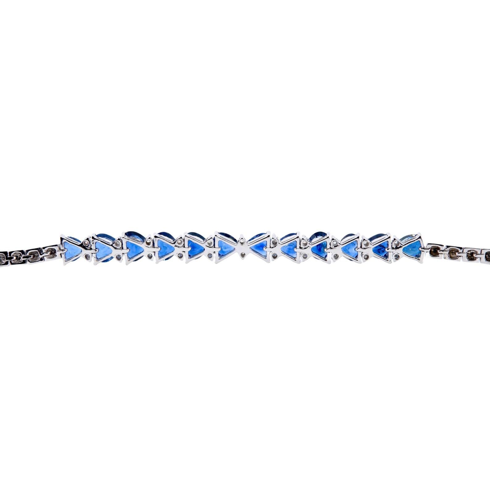 A vintage sapphire, and diamond line bracelet in 18 karat white gold. Set with a dozen rich blue heart shaped sapphires, and accented with brilliant cut white diamonds. 

Weighing 12.00ctw, the sapphires are of rich vivid blue color with superior