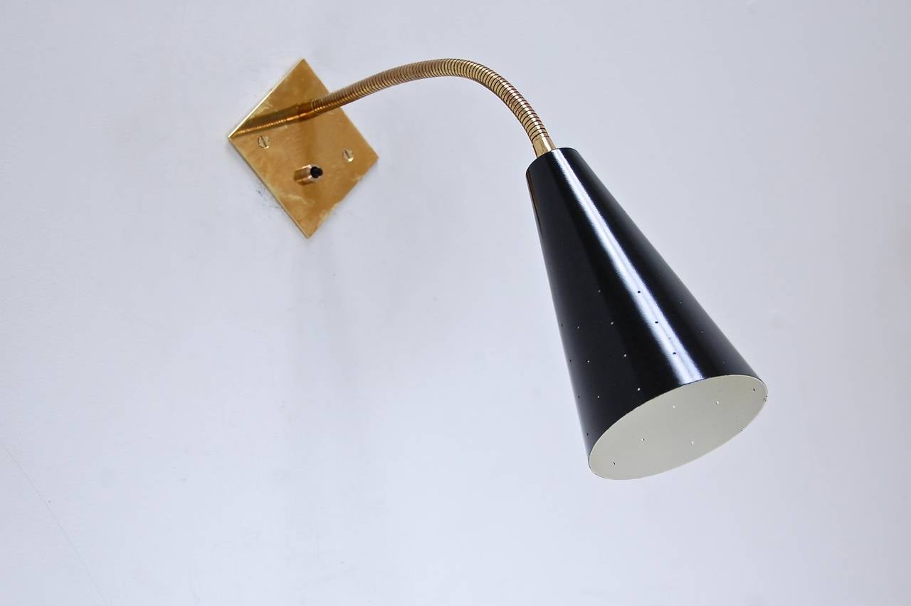 A classic black and brass gooseneck sconce in aged patina brass and painted aluminium. Inspired by 1950s Italian midcentury design, this sconce is ideal for reading areas or a bedside. 1 single E-26 medium based socket. Multiples can be ordered.