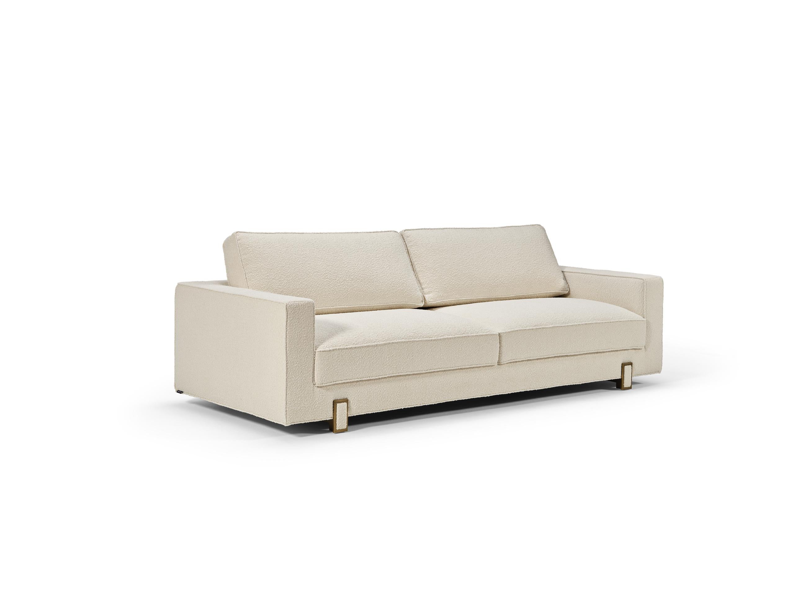 LUSO sofa is a very delicate piece, with special details, designed to be used on a daily basis.‎ Upholstered with two fabrics, using a contrasting piping for an refined result.‎ The feet, in antique brass color, have a fabric detail at the center,