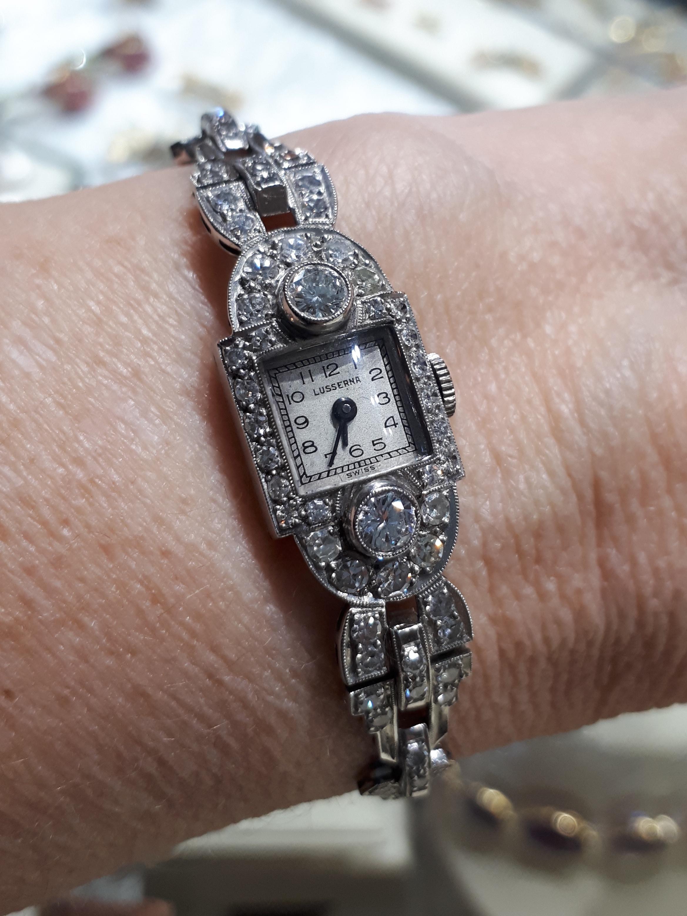 An Art Deco diamond cocktail wristwatch, by Lusserna, with the original, silvered dial, with black enamel Arabic numerals, signed Lusserna, with plain black hands, in a square, two part, platinum case. The square dial is surrounded by eight-cut