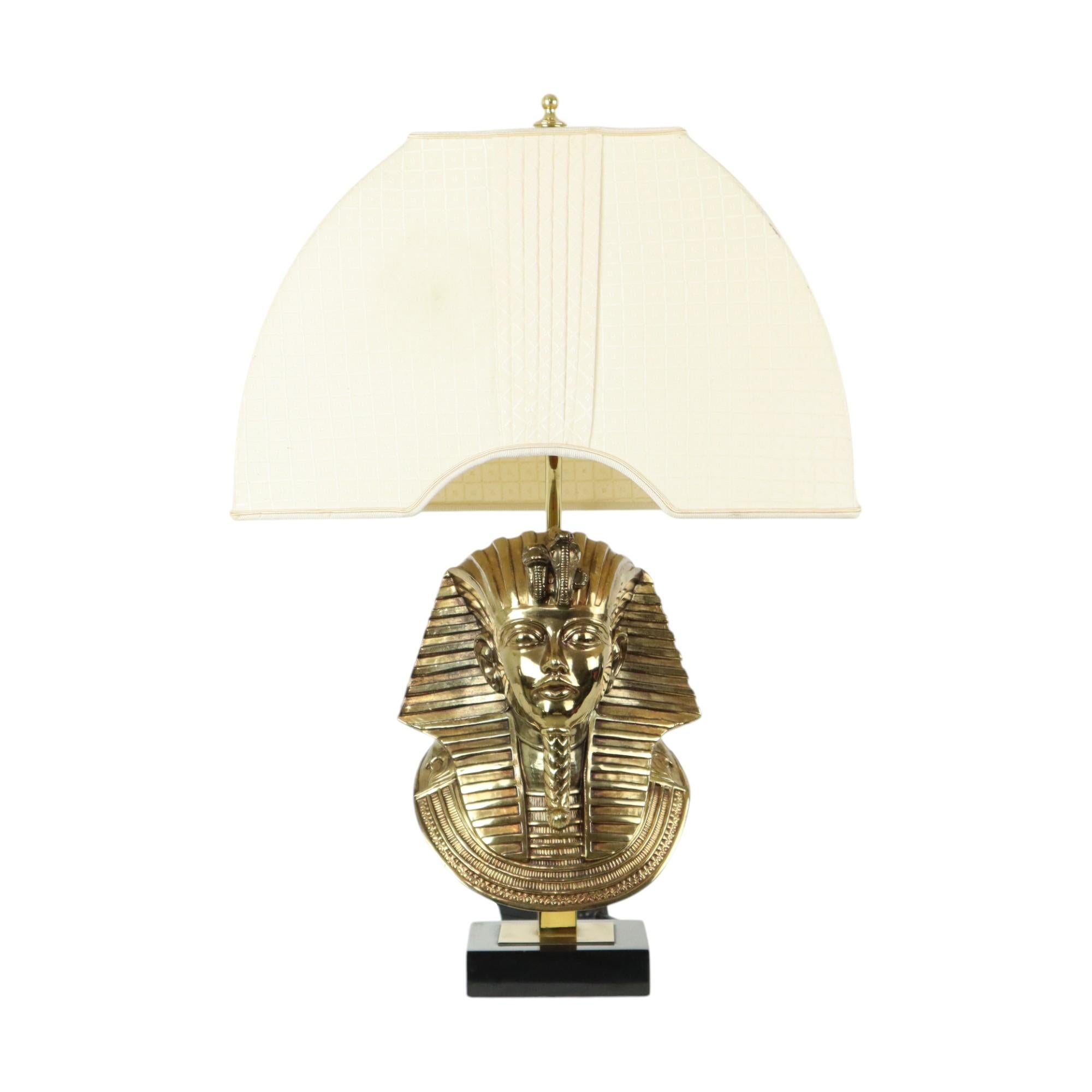 Beautiful Hollywood Regency table lamp in the shape of Pharaoh Tutankhamun, designed by Maison Jansen for Lusterie Deknudt, Belgium, 1970s.

Very high quality table lamp, the pharaoh bust made of brass is mounted on a square noir de Mazy marble