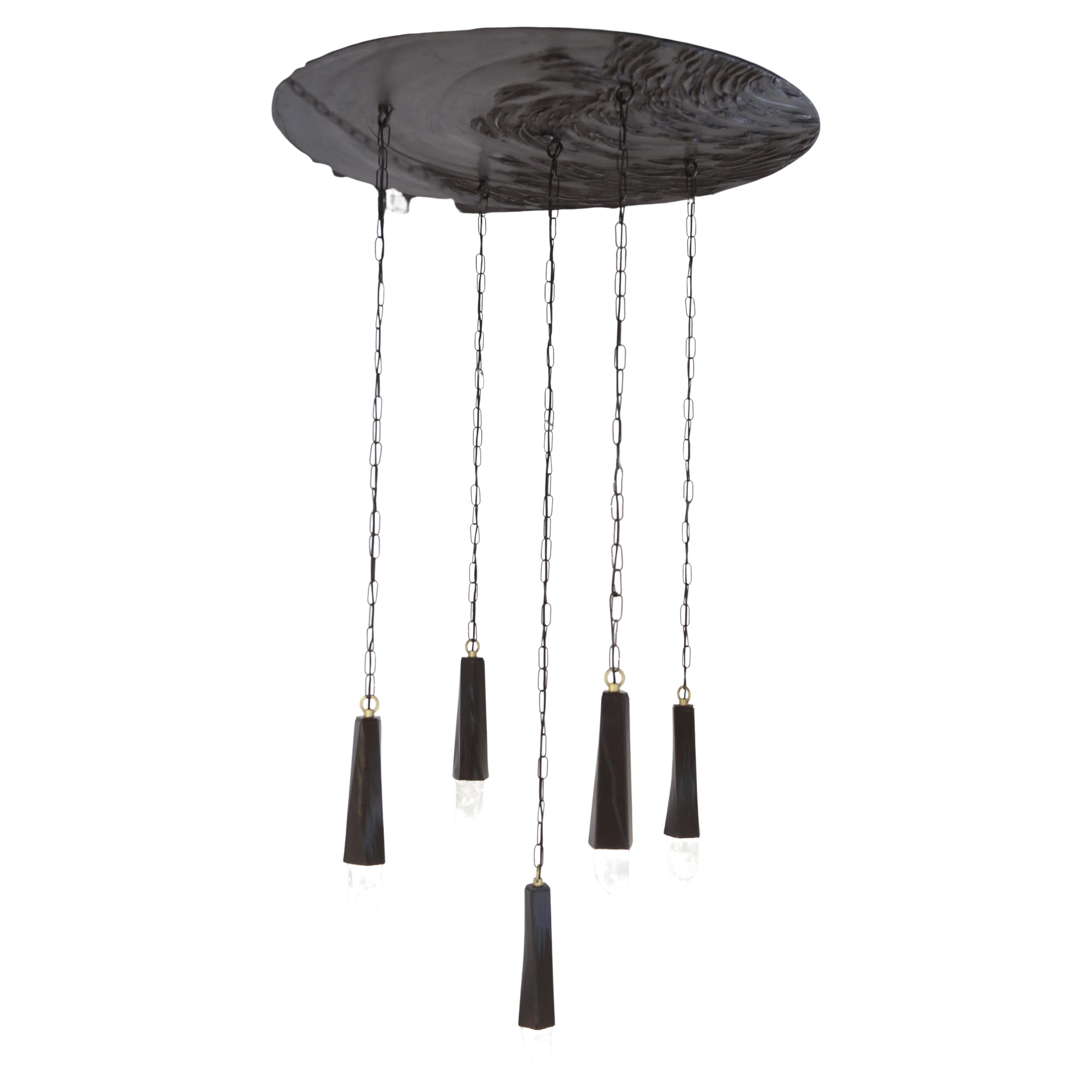 Un lampadario personalizzato con elementi luminosi sospesi. La piastra metallica superiore è rifinita in cromo e gli elementi stampati in 3D sono illuminati con una speciale tecnologia LED.