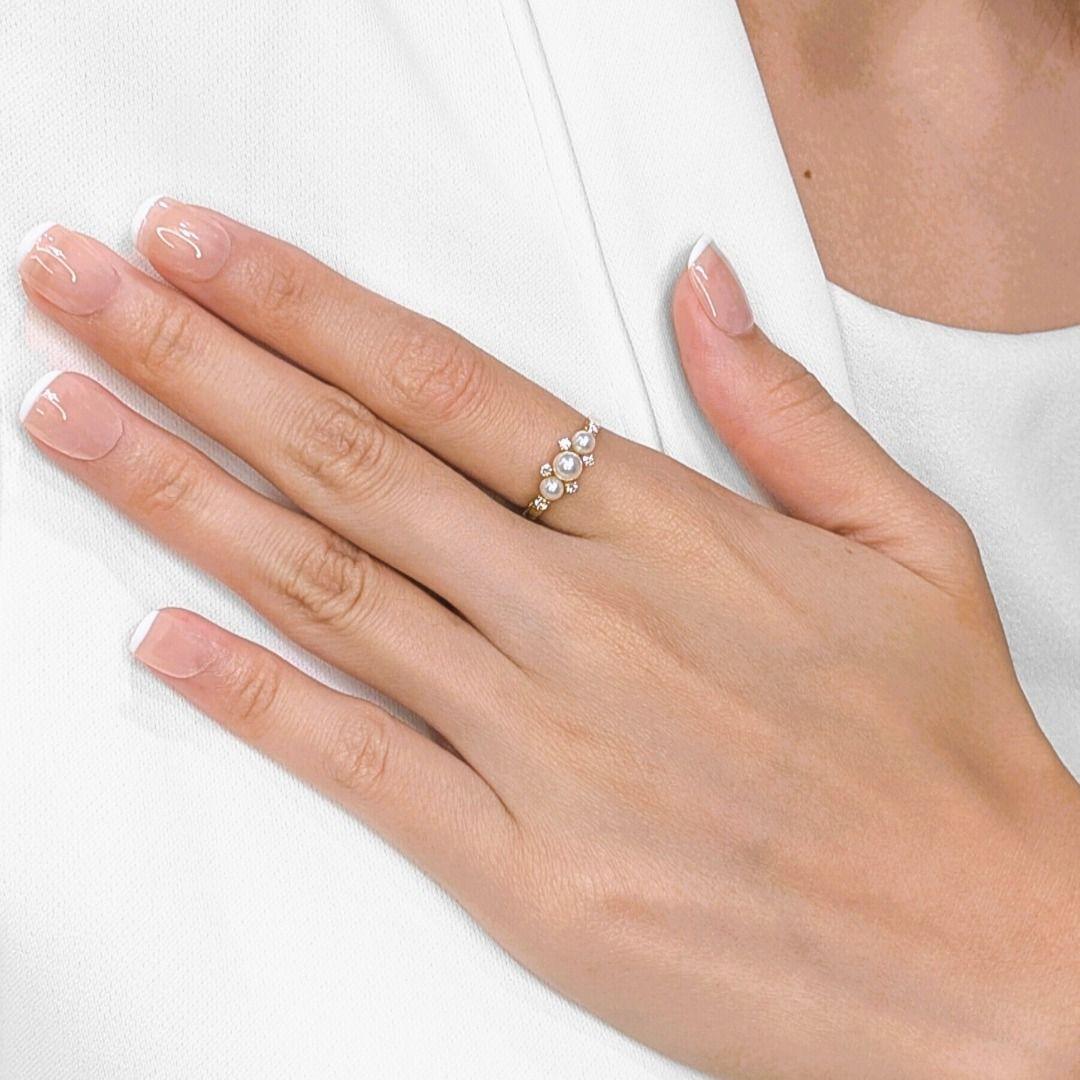 Entdecken Sie den zarten Charme dieses neuen Rings, der sorgfältig aus strahlendem 18 Karat Gelbgold gefertigt ist. Drei schimmernde Akoya-Perlen mit einem Durchmesser von 3,6 mm bis 4,4 mm leuchten in einem zarten rosa-weißen Farbton und sind