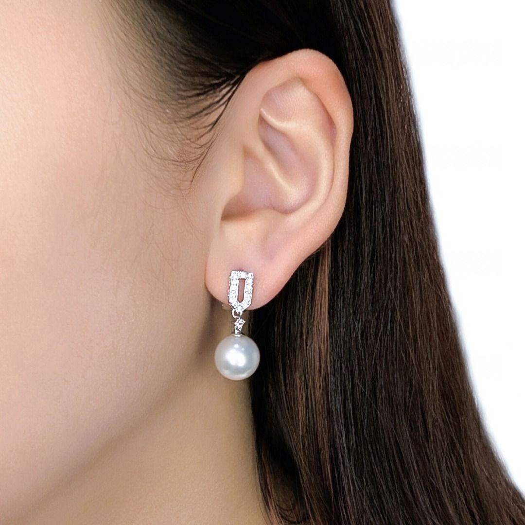Adorn yourself with the exquisite elegance of these lustrous drop earrings, meticulously crafted in radiant 18K white gold and featuring a secure plug setting. Each earring showcases a magnificent 10.2MM round Akoya pearl, renowned for its pristine
